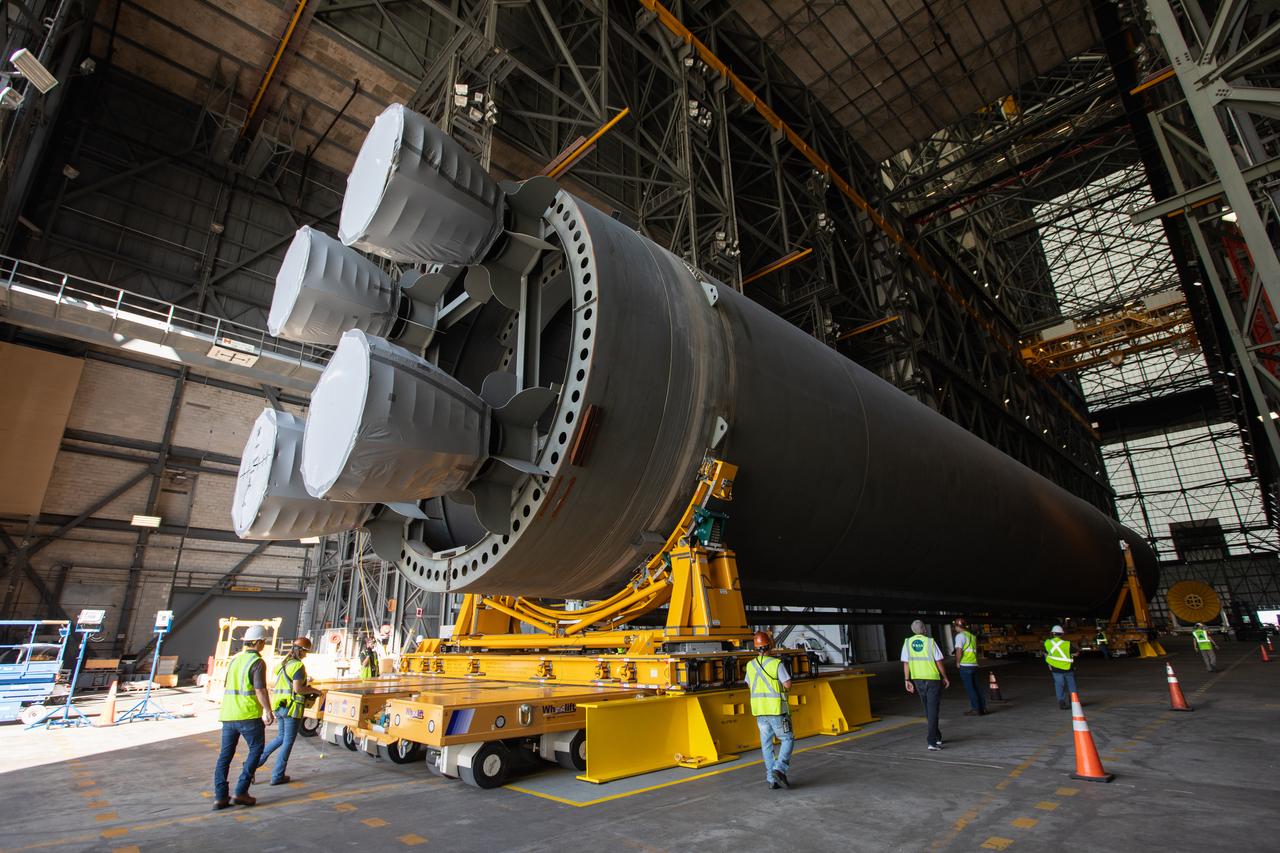 The Space Launch System Core Stage pathfinder is being moved to the north end of the transfer aisle inside the Vehicle Assembly Building at NASA’s Kennedy Space Center in Florida on Oct. 3, 2019. A cover, called a spider, will be attached to the top of the pathfinder. With the spider secured in place, a crane will be attached to it to lift the pathfinder into the vertical position. The 212-foot-long core stage pathfinder arrived in NASA's Pegasus Barge at Kennedy’s Launch Complex 39 turn basin wharf on Sept. 27, 2019. The Pegasus Barge made its first delivery to Kennedy in support of the agency's Artemis missions. The upgraded 310-foot-long barge arrived, ferrying the SLS core stage pathfinder, a full-scale mock-up of the rocket's core stage. It will be used by Exploration Ground Systems and its contractor, Jacobs, to practice offloading, moving and stacking maneuvers, using important ground support equipment to train employees and certify all the equipment works properly. The pathfinder will stay at Kennedy for approximately one month before trekking back to NASA's Michoud Assembly Facility in Louisiana.