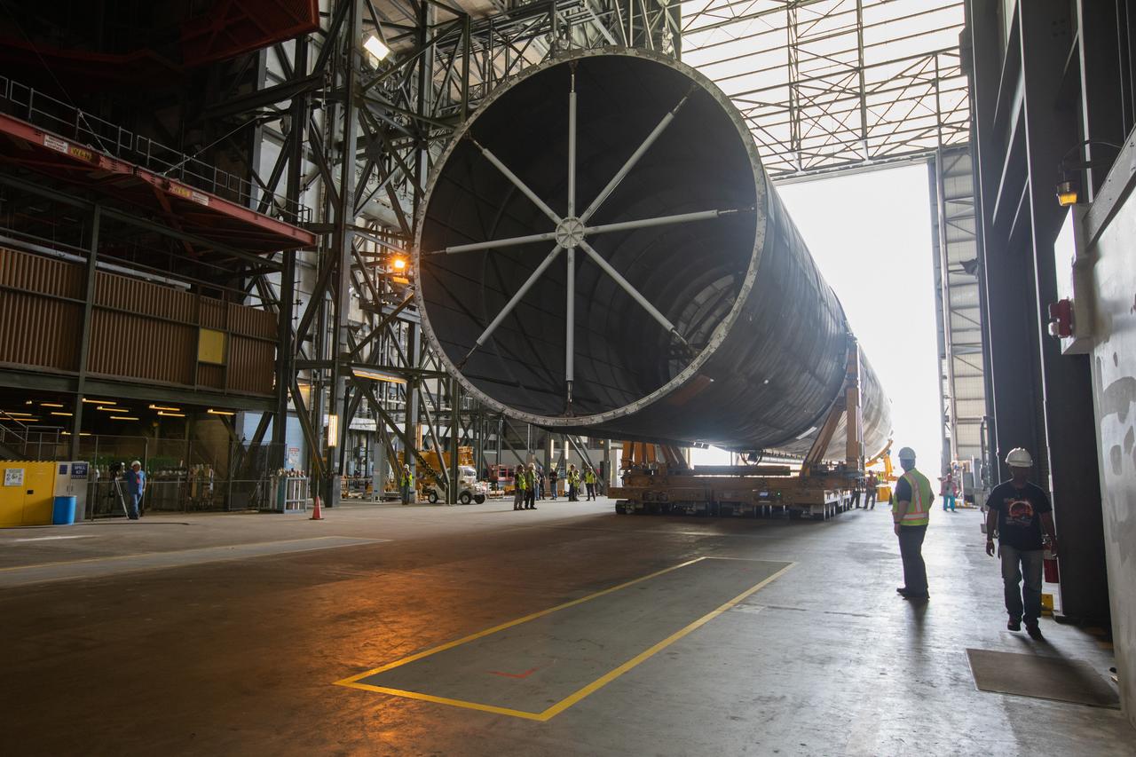 The Space Launch System Core Stage pathfinder is being moved to the north end of the transfer aisle inside the Vehicle Assembly Building at NASA’s Kennedy Space Center in Florida on Oct. 3, 2019. A cover, called a spider, will be attached to the top of the pathfinder. With the spider secured in place, a crane will be attached to it to lift the pathfinder into the vertical position. The 212-foot-long core stage pathfinder arrived in NASA's Pegasus Barge at Kennedy’s Launch Complex 39 turn basin wharf on Sept. 27, 2019. The Pegasus Barge made its first delivery to Kennedy in support of the agency's Artemis missions. The upgraded 310-foot-long barge arrived, ferrying the SLS core stage pathfinder, a full-scale mock-up of the rocket's core stage. It will be used by Exploration Ground Systems and its contractor, Jacobs, to practice offloading, moving and stacking maneuvers, using important ground support equipment to train employees and certify all the equipment works properly. The pathfinder will stay at Kennedy for approximately one month before trekking back to NASA's Michoud Assembly Facility in Louisiana.