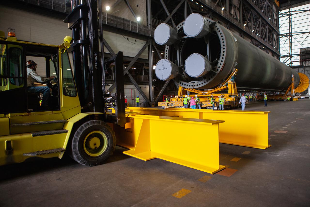 The Space Launch System Core Stage pathfinder is being moved to the north end of the transfer aisle inside the Vehicle Assembly Building at NASA’s Kennedy Space Center in Florida on Oct. 3, 2019. A cover, called a spider, will be attached to the top of the pathfinder. With the spider secured in place, a crane will be attached to it to lift the pathfinder into the vertical position. The 212-foot-long core stage pathfinder arrived in NASA's Pegasus Barge at Kennedy’s Launch Complex 39 turn basin wharf on Sept. 27, 2019. The Pegasus Barge made its first delivery to Kennedy in support of the agency's Artemis missions. The upgraded 310-foot-long barge arrived, ferrying the SLS core stage pathfinder, a full-scale mock-up of the rocket's core stage. It will be used by Exploration Ground Systems and its contractor, Jacobs, to practice offloading, moving and stacking maneuvers, using important ground support equipment to train employees and certify all the equipment works properly. The pathfinder will stay at Kennedy for approximately one month before trekking back to NASA's Michoud Assembly Facility in Louisiana.