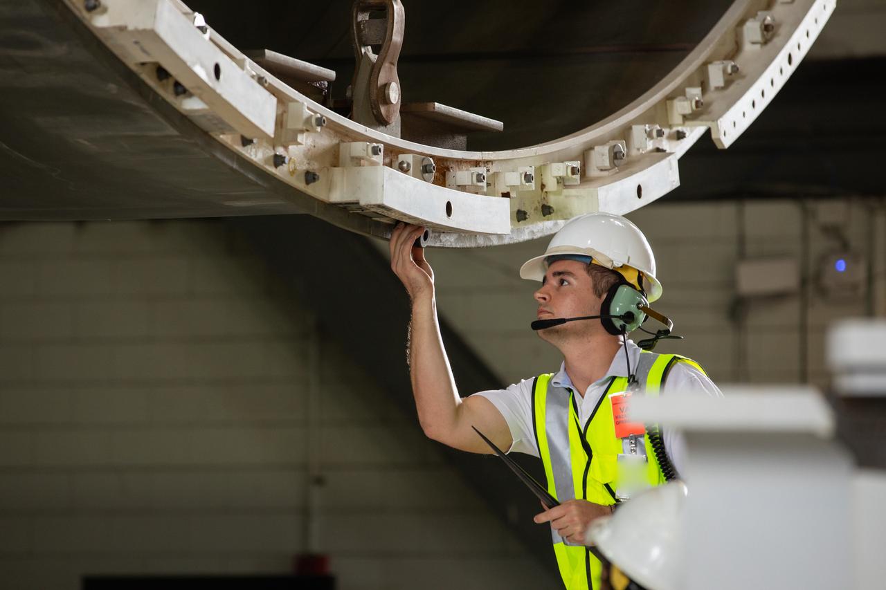 Inside the Vehicle Assembly Building at NASA’s Kennedy Space Center in Florida, a Jacobs TOSC worker monitors the progress as a cover, called the spider, will be attached to the top of the Space Launch System (SLS) Core Stage pathfinder on Oct. 4, 2019. With the spider secured in place, a crane will be attached to it to lift the pathfinder into the vertical position. The 212-foot-long core stage pathfinder arrived on NASA's Pegasus Barge at Kennedy’s Launch Complex 39 turn basin wharf on Sept. 27, 2019. The Pegasus Barge made its first delivery to Kennedy in support of the agency's Artemis missions. The upgraded 310-foot-long barge arrived, ferrying the SLS core stage pathfinder, a full-scale mock-up of the rocket's core stage. It will be used by Exploration Ground Systems and its contractor, Jacobs, to practice offloading, moving and stacking maneuvers, using important ground support equipment to train employees and certify all the equipment works properly. The pathfinder will stay at Kennedy for approximately one month before trekking back to NASA's Michoud Assembly Facility in Louisiana.