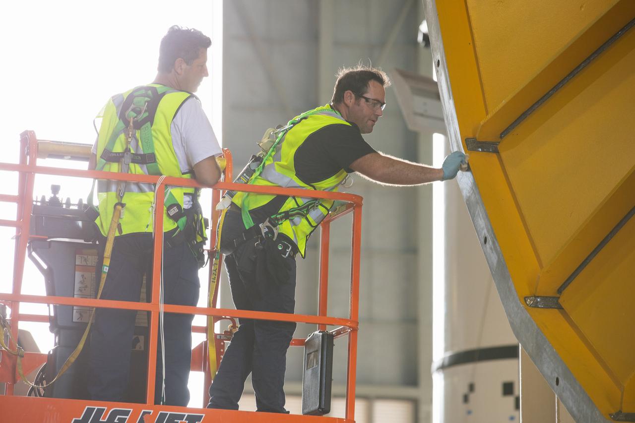 Inside the Vehicle Assembly Building at NASA’s Kennedy Space Center in Florida, NASA and Jacobs TOSC workers monitor the progress as a cover, called the spider, will be attached to the top of the Space Launch System (SLS) Core Stage pathfinder on Oct. 4, 2019. With the spider secured in place, a crane will be attached to it to lift the pathfinder into the vertical position. The 212-foot-long core stage pathfinder arrived on NASA's Pegasus Barge at Kennedy’s Launch Complex 39 turn basin wharf on Sept. 27, 2019. The Pegasus Barge made its first delivery to Kennedy in support of the agency's Artemis missions. The upgraded 310-foot-long barge arrived, ferrying the SLS core stage pathfinder, a full-scale mock-up of the rocket's core stage. It will be used by Exploration Ground Systems and its contractor, Jacobs, to practice offloading, moving and stacking maneuvers, using important ground support equipment to train employees and certify all the equipment works properly. The pathfinder will stay at Kennedy for approximately one month before trekking back to NASA's Michoud Assembly Facility in Louisiana.