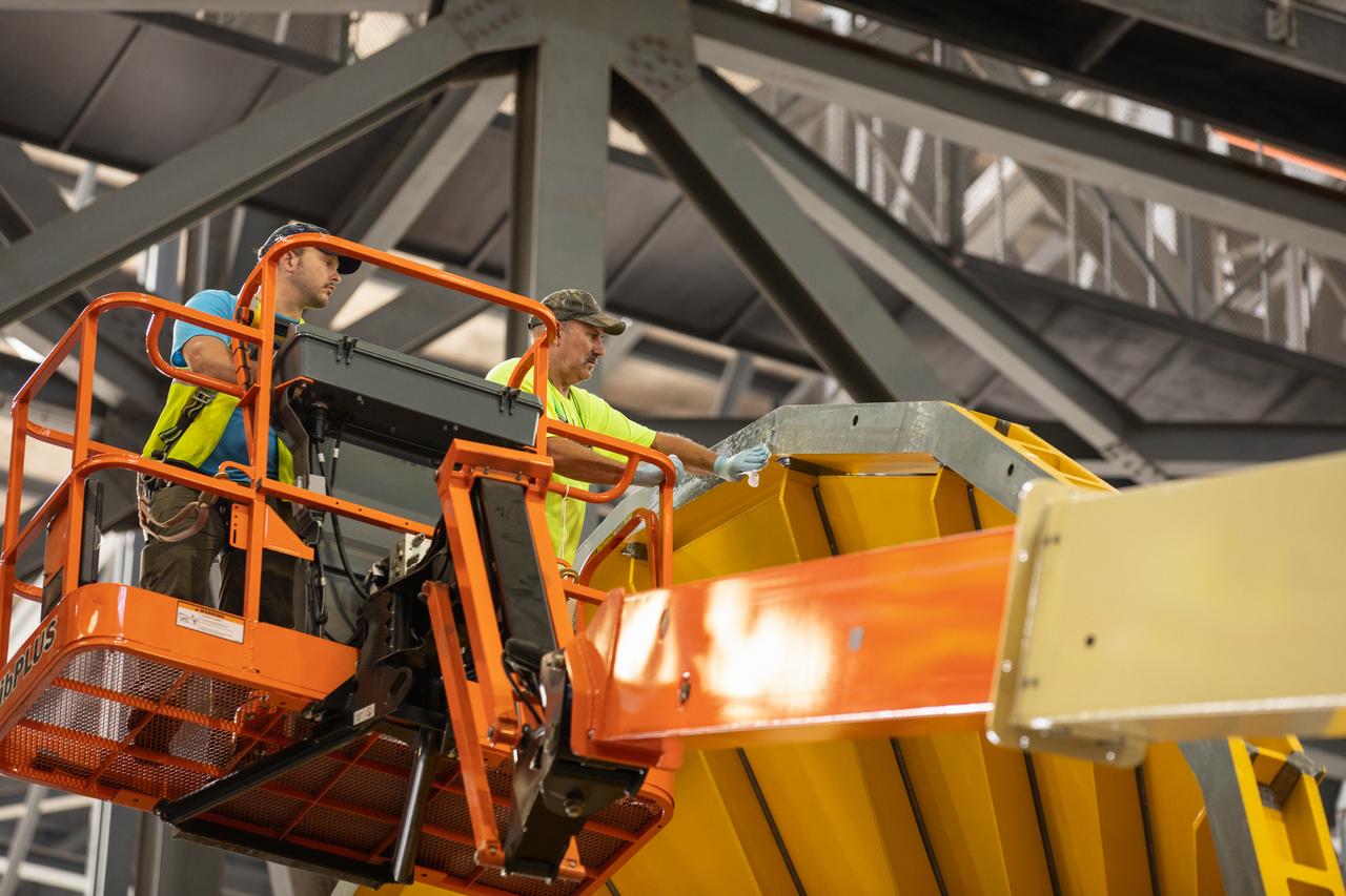 Inside the Vehicle Assembly Building at NASA’s Kennedy Space Center in Florida, Jacobs TOSC workers assist as a cover, called the spider, is moved closer to be attached to the top of the Space Launch System (SLS) Core Stage pathfinder on Oct. 4, 2019. With the spider secured in place, a crane will be attached to it to lift the pathfinder into the vertical position. The 212-foot-long core stage pathfinder arrived on NASA's Pegasus Barge at Kennedy’s Launch Complex 39 turn basin wharf on Sept. 27, 2019. The Pegasus Barge made its first delivery to Kennedy in support of the agency's Artemis missions. The upgraded 310-foot-long barge arrived, ferrying the SLS core stage pathfinder, a full-scale mock-up of the rocket's core stage. It will be used by Exploration Ground Systems and its contractor, Jacobs, to practice offloading, moving and stacking maneuvers, using important ground support equipment to train employees and certify all the equipment works properly. The pathfinder will stay at Kennedy for approximately one month before trekking back to NASA's Michoud Assembly Facility in Louisiana.