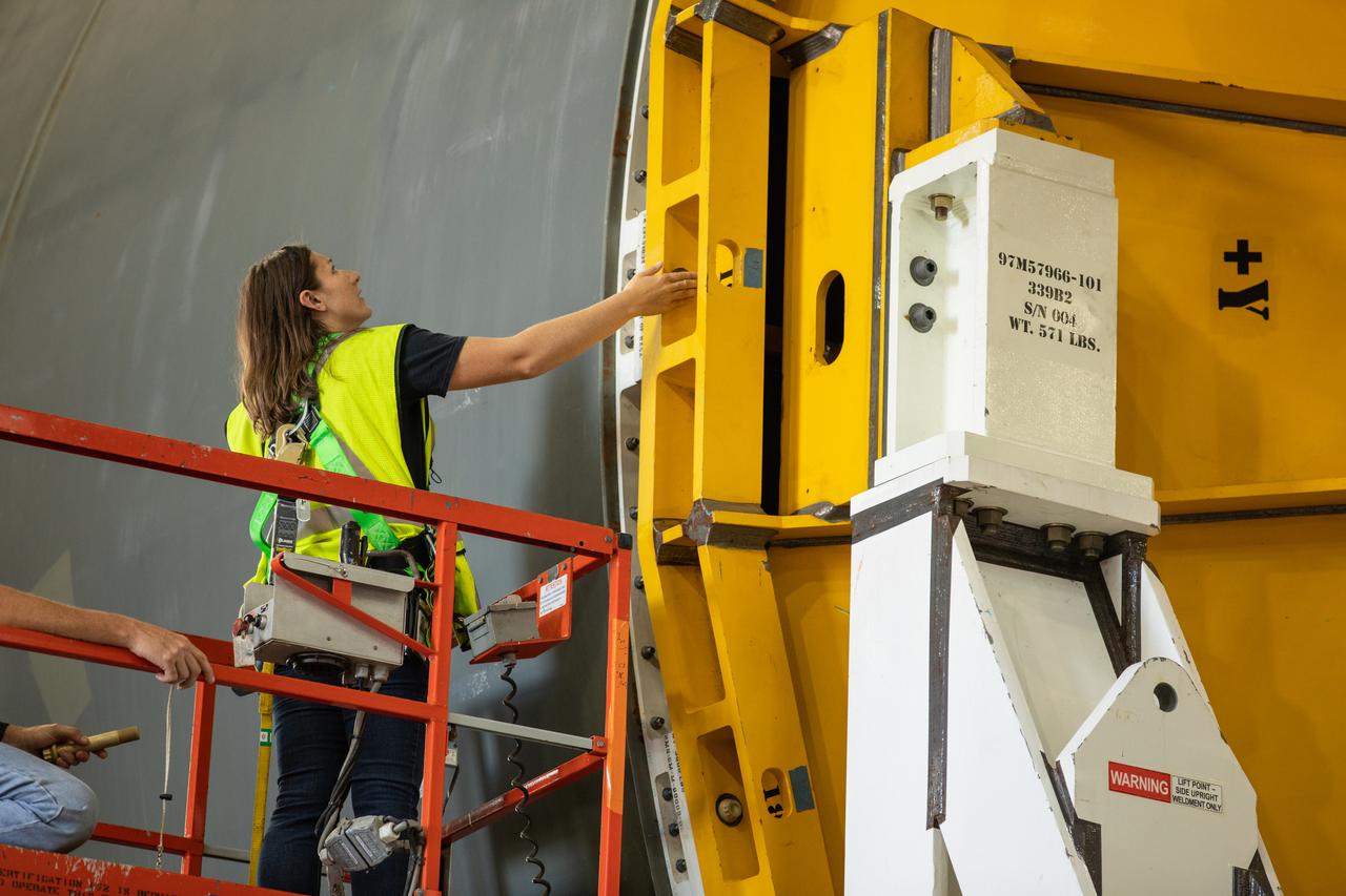 Inside the Vehicle Assembly Building at NASA’s Kennedy Space Center in Florida, a Jacobs TOSC worker assists as a cover, called a spider, is attached to the top of the Space Launch System (SLS) Core Stage pathfinder on Oct. 4, 2019. With the spider secured in place, a crane will be attached to it to lift the pathfinder into the vertical position. The 212-foot-long core stage pathfinder arrived on NASA's Pegasus Barge at Kennedy’s Launch Complex 39 turn basin wharf on Sept. 27, 2019. The Pegasus Barge made its first delivery to Kennedy in support of the agency's Artemis missions. The upgraded 310-foot-long barge arrived, ferrying the SLS core stage pathfinder, a full-scale mock-up of the rocket's core stage. It will be used by Exploration Ground Systems and its contractor, Jacobs, to practice offloading, moving and stacking maneuvers, using important ground support equipment to train employees and certify all the equipment works properly. The pathfinder will stay at Kennedy for approximately one month before trekking back to NASA's Michoud Assembly Facility in Louisiana.