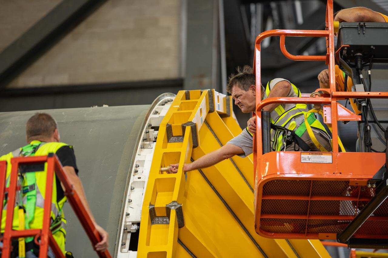 Inside the Vehicle Assembly Building at NASA’s Kennedy Space Center in Florida, Jacobs TOSC workers help attach a cover, called a spider, to the top of the Space Launch System (SLS) Core Stage pathfinder on Oct. 4, 2019. With the spider secured in place, a crane will be attached to it to lift the pathfinder into the vertical position. The 212-foot-long core stage pathfinder arrived on NASA's Pegasus Barge at Kennedy’s Launch Complex 39 turn basin wharf on Sept. 27, 2019. The Pegasus Barge made its first delivery to Kennedy in support of the agency's Artemis missions. The upgraded 310-foot-long barge arrived, ferrying the SLS core stage pathfinder, a full-scale mock-up of the rocket's core stage. It will be used by Exploration Ground Systems and its contractor, Jacobs, to practice offloading, moving and stacking maneuvers, using important ground support equipment to train employees and certify all the equipment works properly. The pathfinder will stay at Kennedy for approximately one month before trekking back to NASA's Michoud Assembly Facility in Louisiana.