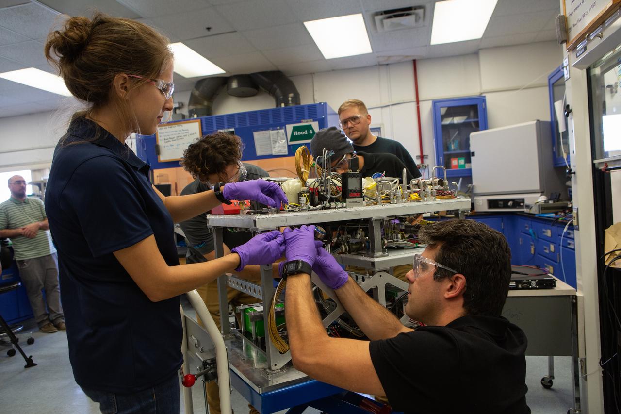 Team members assemble the flight hardware for NASA’s Orbital Syngas Commodity Augmentation Reactor, or OSCAR, on Oct. 10, 2019, in the Space Station Processing Facility at the agency’s Kennedy Space Center in Florida. From left are Annie Meier, Gino Carro, Evan Bell and Jamie Toro. OSCAR is an Early Career Initiative project at the spaceport that studies technology to convert trash and human waste into useful gasses such as methane, hydrogen and carbon dioxide. By processing small pieces of trash in a high-temperature reactor, OSCAR is advancing new and innovative technology for managing waste in space. A prototype has been developed, and the team is in the process of constructing a new rig for a suborbital flight test.
