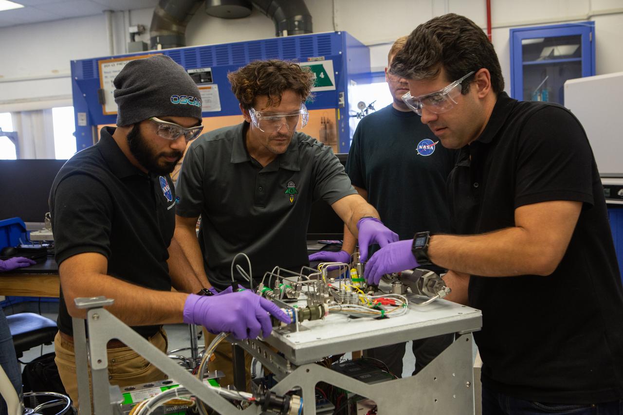 From left, team members Malay Shah, Gino Carro, Evan Bell and Jamie Toro assemble the flight hardware for NASA’s Orbital Syngas Commodity Augmentation Reactor, or OSCAR, on Oct. 10, 2019, in the Space Station Processing Facility at the agency’s Kennedy Space Center in Florida. OSCAR is an Early Career Initiative project at the spaceport that studies technology to convert trash and human waste into useful gasses such as methane, hydrogen and carbon dioxide. By processing small pieces of trash in a high-temperature reactor, OSCAR is advancing new and innovative technology for managing waste in space. A prototype has been developed, and the team is in the process of constructing a new rig for a suborbital flight test.
