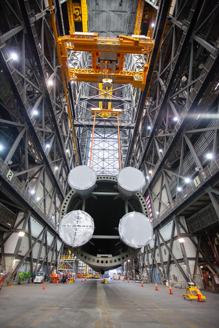 Inside the Vehicle Assembly Building at NASA’s Kennedy Space Center in Florida, two cranes are used to lift the Space Launch System (SLS) Core Stage pathfinder horizontally in the transfer aisle on Oct. 15, 2019. The 212-foot-long core stage pathfinder arrived on NASA's Pegasus Barge at Kennedy’s Launch Complex 39 turn basin wharf on Sept. 27, 2019. The Pegasus Barge made its first delivery to Kennedy in support of the agency's Artemis missions. The pathfinder is being used by Exploration Ground Systems and its contractor, Jacobs, to practice offloading, moving and stacking maneuvers, using important ground support equipment to train employees and certify all the equipment works properly. The pathfinder will stay at Kennedy through at least the month of October before trekking back to NASA's Michoud Assembly Facility in Louisiana.