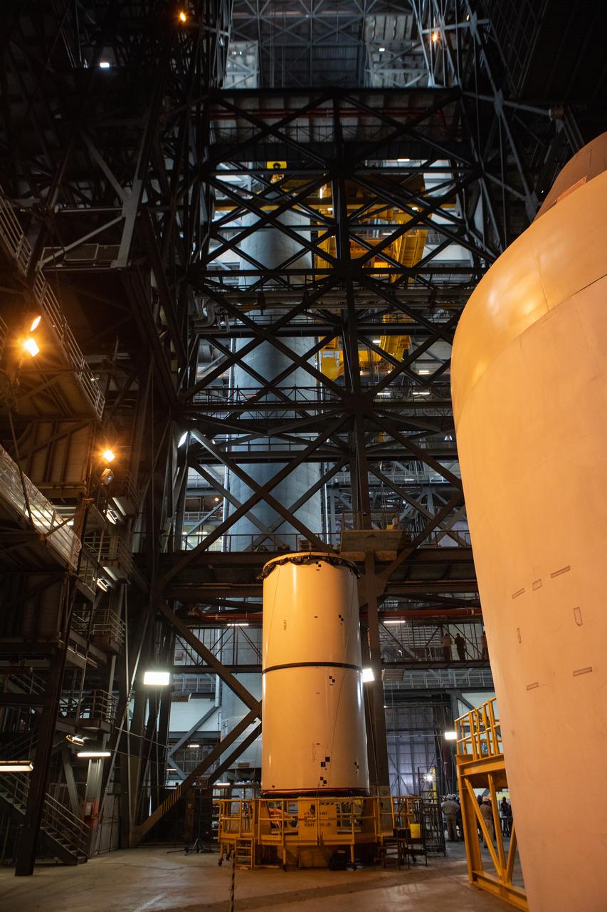 Inside the Vehicle Assembly Building at NASA’s Kennedy Space Center in Florida, the Space Launch System (SLS) Core Stage pathfinder is lifted into the vertical position in the transfer aisle on Oct. 15, 2019. In the foreground is a portion of a pathfinder booster. The 212-foot-long core stage pathfinder arrived on NASA's Pegasus Barge at Kennedy’s Launch Complex 39 turn basin wharf on Sept. 27, 2019. The Pegasus Barge made its first delivery to Kennedy in support of the agency's Artemis missions. The pathfinder is being used by Exploration Ground Systems and its contractor, Jacobs, to practice offloading, moving and stacking maneuvers, using important ground support equipment to train employees and certify all the equipment works properly. The pathfinder will stay at Kennedy through at least the month of October before trekking back to NASA's Michoud Assembly Facility in Louisiana. 