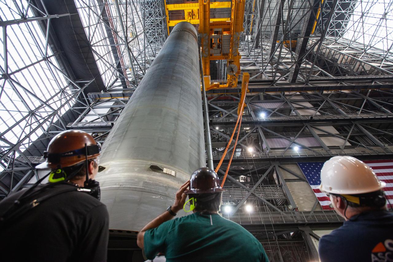 Inside the Vehicle Assembly Building at NASA’s Kennedy Space Center in Florida, workers watch as a crane is used to lift the Space Launch System (SLS) Core Stage pathfinder into the vertical position in the transfer aisle on Oct. 15, 2019. The 212-foot-long core stage pathfinder arrived on NASA's Pegasus Barge at Kennedy’s Launch Complex 39 turn basin wharf on Sept. 27, 2019. The Pegasus Barge made its first delivery to Kennedy in support of the agency's Artemis missions. The pathfinder is being used by Exploration Ground Systems and its contractor, Jacobs, to practice offloading, moving and stacking maneuvers, using important ground support equipment to train employees and certify all the equipment works properly. The pathfinder will stay at Kennedy through at least the month of October before trekking back to NASA's Michoud Assembly Facility in Louisiana.