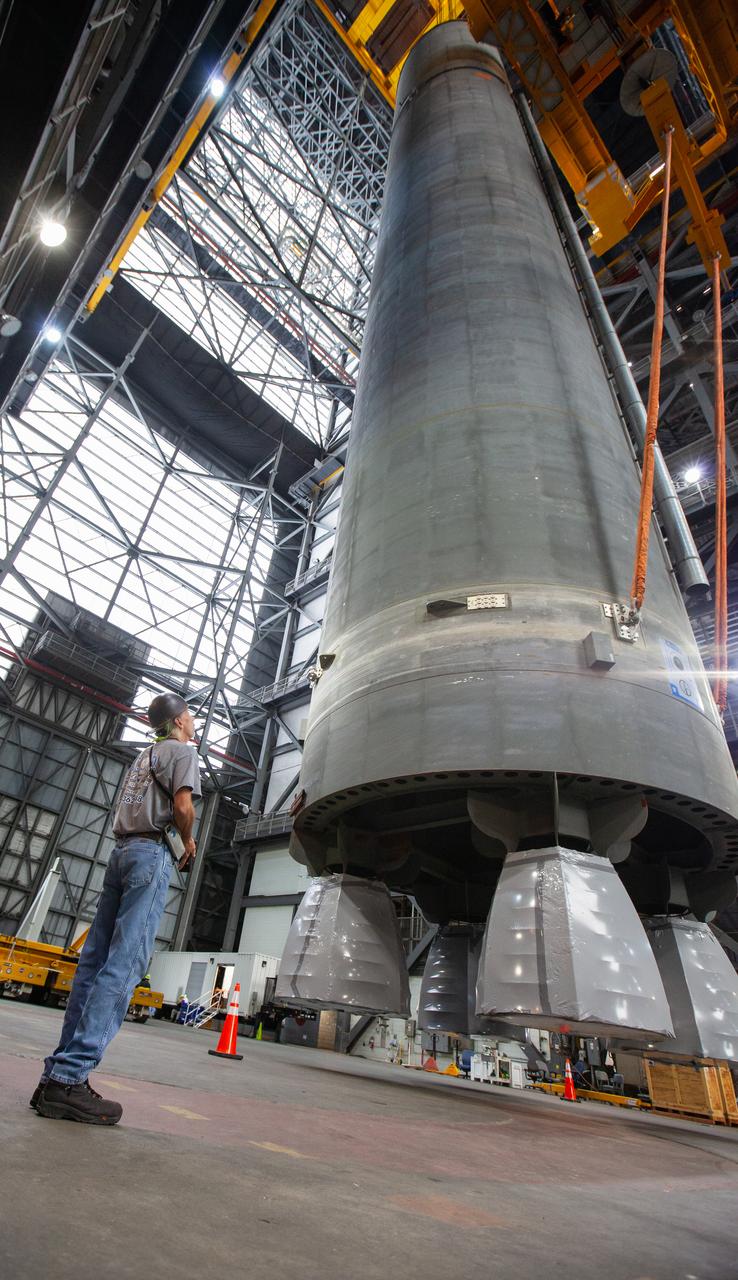 Inside the Vehicle Assembly Building at NASA’s Kennedy Space Center in Florida, a technician watches as a crane is used to lift the Space Launch System (SLS) Core Stage pathfinder into the vertical position in the transfer aisle on Oct. 15, 2019. The 212-foot-long core stage pathfinder arrived on NASA's Pegasus Barge at Kennedy’s Launch Complex 39 turn basin wharf on Sept. 27, 2019. The Pegasus Barge made its first delivery to Kennedy in support of the agency's Artemis missions. The pathfinder is being used by Exploration Ground Systems and its contractor, Jacobs, to practice offloading, moving and stacking maneuvers, using important ground support equipment to train employees and certify all the equipment works properly. The pathfinder will stay at Kennedy through at least the month of October before trekking back to NASA's Michoud Assembly Facility in Louisiana.