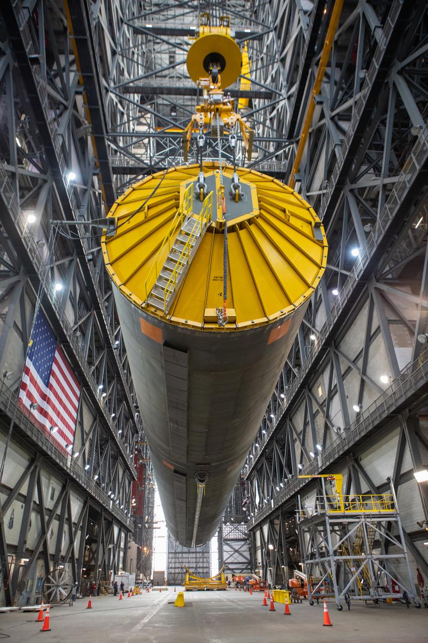 Inside the Vehicle Assembly Building at NASA’s Kennedy Space Center in Florida, the Space Launch System (SLS) Core Stage pathfinder is suspended by two cranes in the horizontal position above the transfer aisle on Oct. 15, 2019. The 212-foot-long core stage pathfinder arrived on NASA's Pegasus Barge at Kennedy’s Launch Complex 39 turn basin wharf on Sept. 27, 2019. The Pegasus Barge made its first delivery to Kennedy in support of the agency's Artemis missions. The pathfinder is being used by Exploration Ground Systems and its contractor, Jacobs, to practice offloading, moving and stacking maneuvers, using important ground support equipment to train employees and certify all the equipment works properly. The pathfinder will stay at Kennedy through at least the month of October before trekking back to NASA's Michoud Assembly Facility in Louisiana.