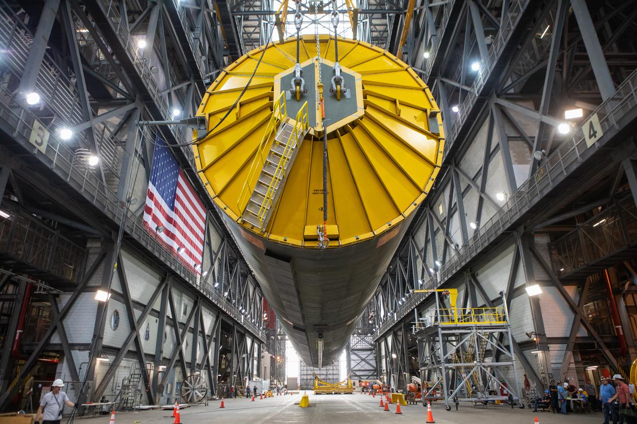 Inside the Vehicle Assembly Building at NASA’s Kennedy Space Center in Florida, the Space Launch System (SLS) Core Stage pathfinder is suspended by two cranes in the horizontal position above the transfer aisle on Oct. 15, 2019. The 212-foot-long core stage pathfinder arrived on NASA's Pegasus Barge at Kennedy’s Launch Complex 39 turn basin wharf on Sept. 27, 2019. The Pegasus Barge made its first delivery to Kennedy in support of the agency's Artemis missions. The pathfinder is being used by Exploration Ground Systems and its contractor, Jacobs, to practice offloading, moving and stacking maneuvers, using important ground support equipment to train employees and certify all the equipment works properly. The pathfinder will stay at Kennedy through at least the month of October before trekking back to NASA's Michoud Assembly Facility in Louisiana.