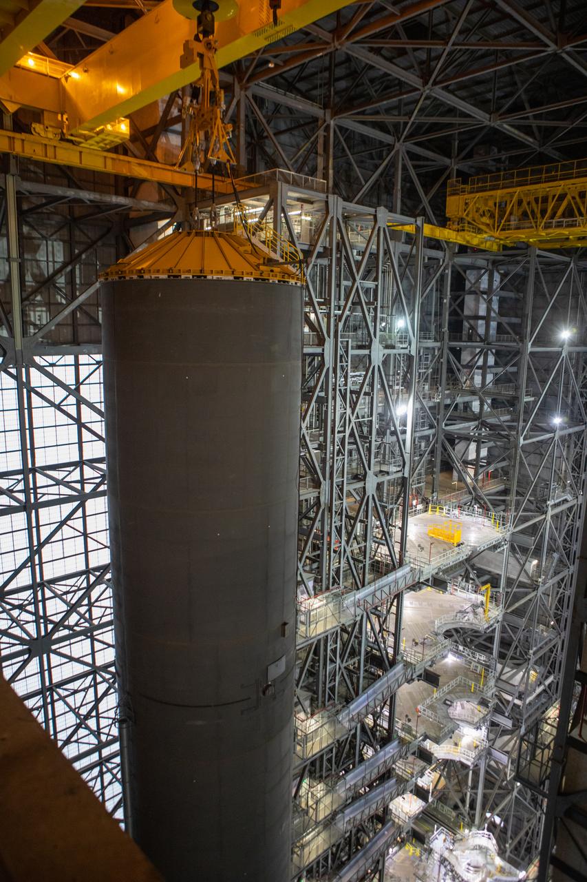 Inside the Vehicle Assembly Building at NASA’s Kennedy Space Center in Florida, a crane is used to lift the Space Launch System (SLS) Core Stage pathfinder high up in the transfer aisle on Oct. 16, 2019. The pathfinder is being lifted up to the 16th level and will be lowered into High Bay 3. The 212-foot-long core stage pathfinder arrived on NASA's Pegasus Barge at Kennedy’s Launch Complex 39 turn basin wharf on Sept. 27, 2019. The Pegasus Barge made its first delivery to Kennedy in support of the agency's Artemis missions. The pathfinder is being used by Exploration Ground Systems and its contractor, Jacobs, to practice offloading, moving and stacking maneuvers, using important ground support equipment to train employees and certify all the equipment works properly. The pathfinder will stay at Kennedy through at least the month of October before trekking back to NASA's Michoud Assembly Facility in Louisiana.