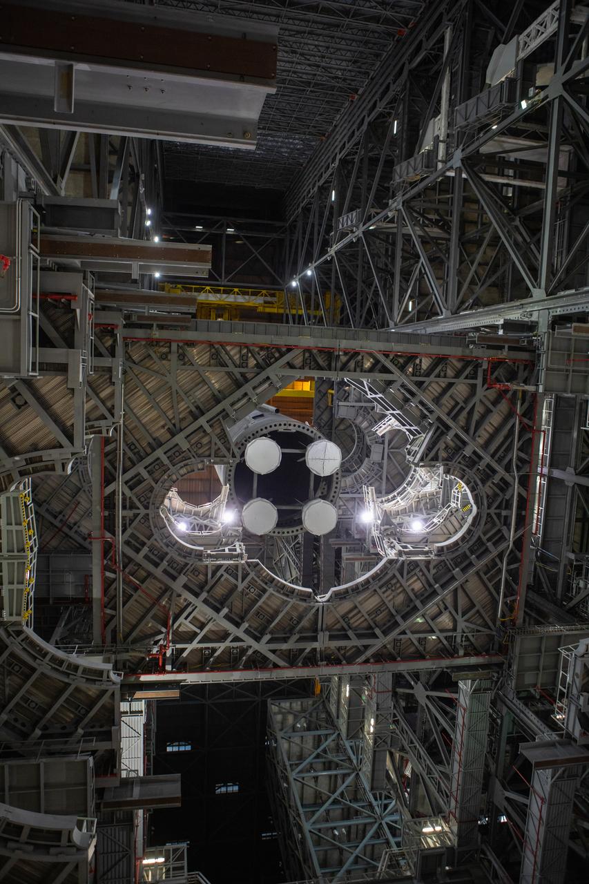 In this view looking up inside the Vehicle Assembly Building at NASA’s Kennedy Space Center in Florida, a crane lowers the Space Launch System (SLS) Core Stage pathfinder into High Bay 3 on Oct. 16, 2019. The 212-foot-long core stage pathfinder arrived on NASA's Pegasus Barge at Kennedy’s Launch Complex 39 turn basin wharf on Sept. 27, 2019. The Pegasus Barge made its first delivery to Kennedy in support of the agency's Artemis missions. The pathfinder is being used by Exploration Ground Systems and its contractor, Jacobs, to practice offloading, moving and stacking maneuvers, using important ground support equipment to train employees and certify all the equipment works properly. The pathfinder will stay at Kennedy through at least the month of October before trekking back to NASA's Michoud Assembly Facility in Louisiana.
