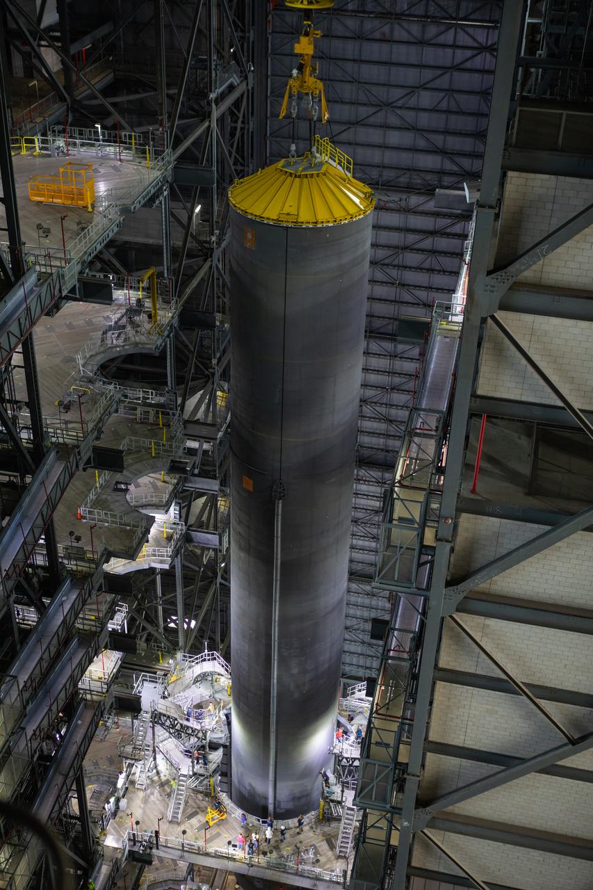 Inside the Vehicle Assembly Building at NASA’s Kennedy Space Center in Florida, a crane lowers the Space Launch System (SLS) Core Stage pathfinder into High Bay 3 on Oct. 65, 2019. The 212-foot-long core stage pathfinder arrived on NASA's Pegasus Barge at Kennedy’s Launch Complex 39 turn basin wharf on Sept. 27, 2019. The Pegasus Barge made its first delivery to Kennedy in support of the agency's Artemis missions. The pathfinder is being used by Exploration Ground Systems and its contractor, Jacobs, to practice offloading, moving and stacking maneuvers, using important ground support equipment to train employees and certify all the equipment works properly. The pathfinder will stay at Kennedy through at least the month of October before trekking back to NASA's Michoud Assembly Facility in Louisiana.