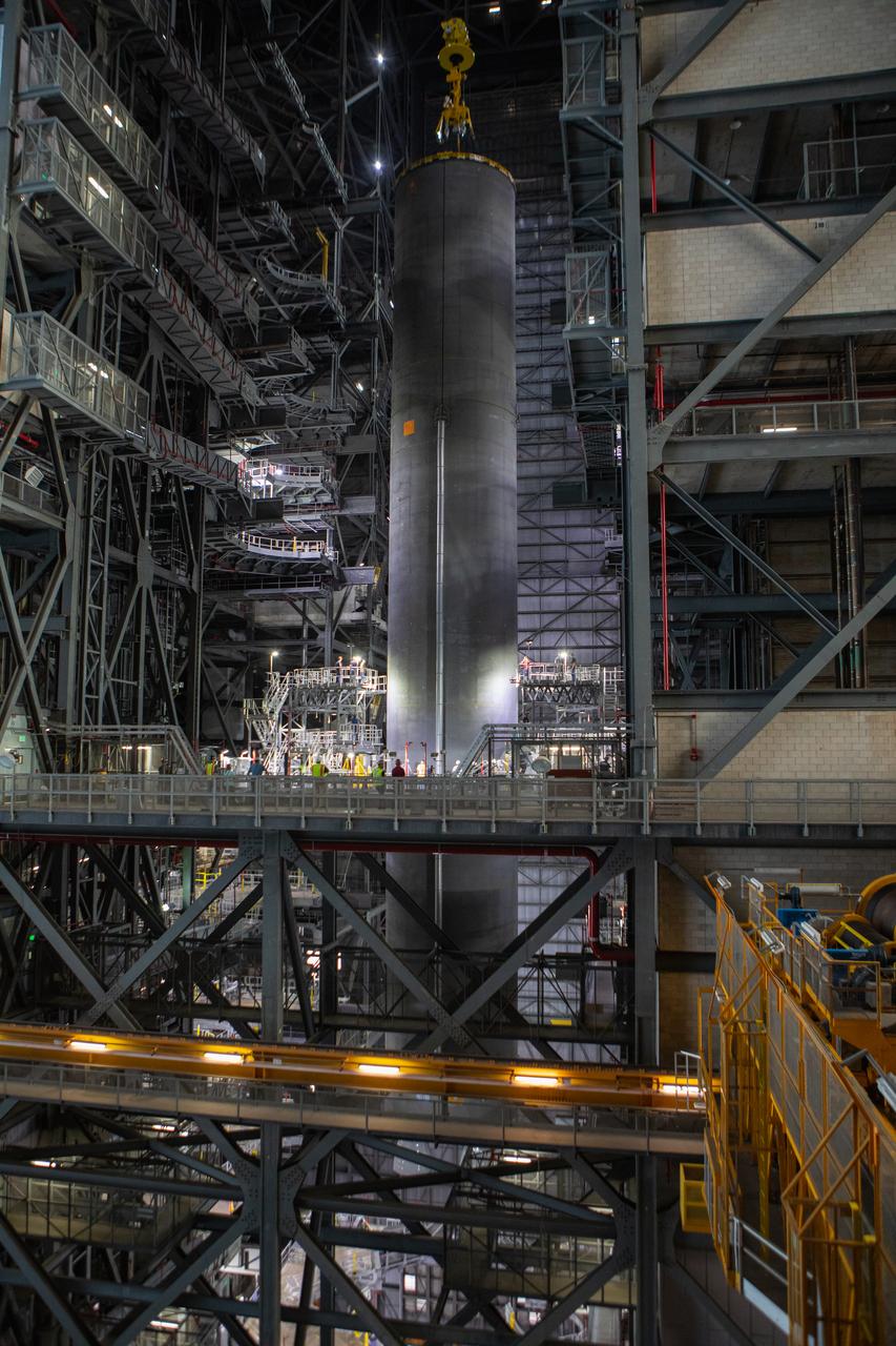 Inside the Vehicle Assembly Building at NASA’s Kennedy Space Center in Florida, a crane lowers the Space Launch System (SLS) Core Stage pathfinder into High Bay 3 on Oct. 65, 2019. The 212-foot-long core stage pathfinder arrived on NASA's Pegasus Barge at Kennedy’s Launch Complex 39 turn basin wharf on Sept. 27, 2019. The Pegasus Barge made its first delivery to Kennedy in support of the agency's Artemis missions. The pathfinder is being used by Exploration Ground Systems and its contractor, Jacobs, to practice offloading, moving and stacking maneuvers, using important ground support equipment to train employees and certify all the equipment works properly. The pathfinder will stay at Kennedy through at least the month of October before trekking back to NASA's Michoud Assembly Facility in Louisiana.