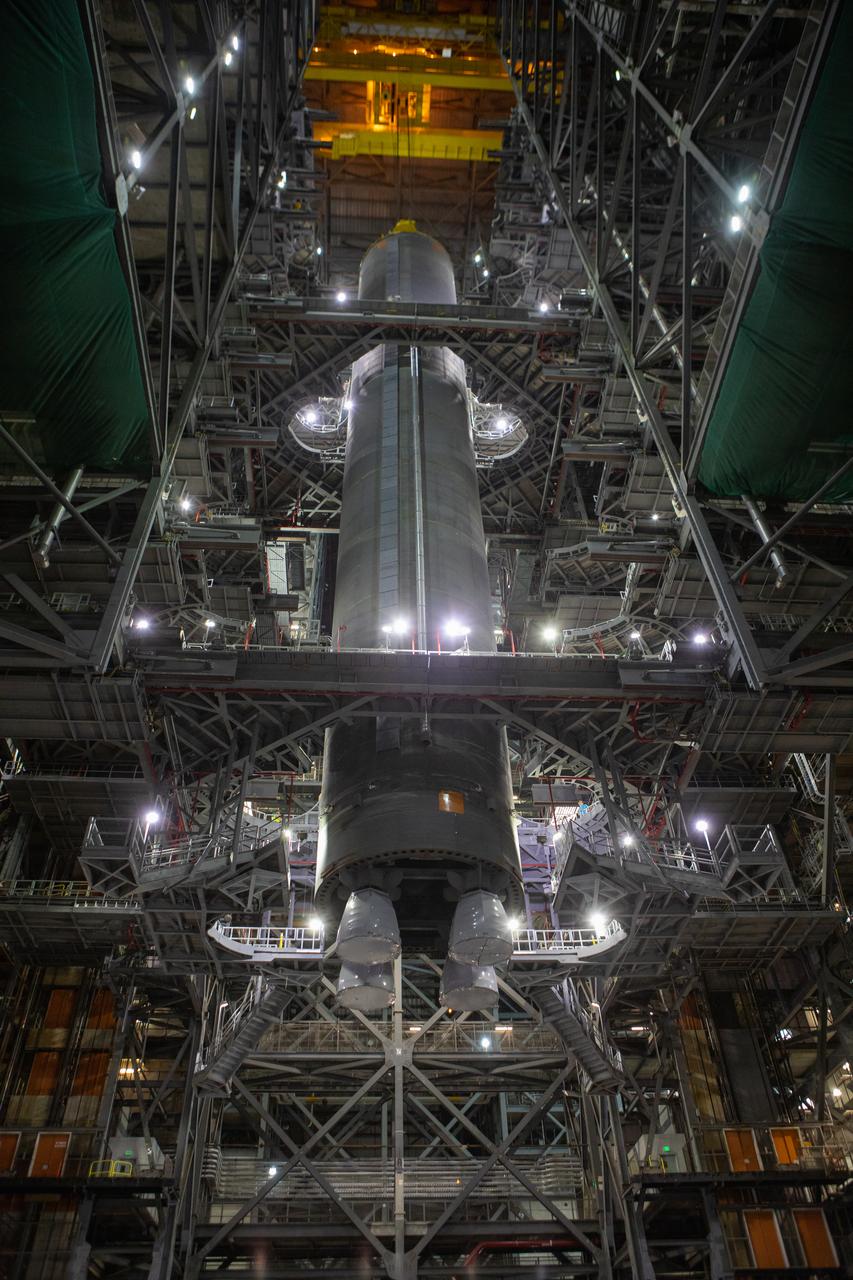 Inside the Vehicle Assembly Building at NASA’s Kennedy Space Center in Florida, a crane lowers the Space Launch System (SLS) Core Stage pathfinder into High Bay 3 on Oct. 65, 2019. The 212-foot-long core stage pathfinder arrived on NASA's Pegasus Barge at Kennedy’s Launch Complex 39 turn basin wharf on Sept. 27, 2019. The Pegasus Barge made its first delivery to Kennedy in support of the agency's Artemis missions. The pathfinder is being used by Exploration Ground Systems and its contractor, Jacobs, to practice offloading, moving and stacking maneuvers, using important ground support equipment to train employees and certify all the equipment works properly. The pathfinder will stay at Kennedy through at least the month of October before trekking back to NASA's Michoud Assembly Facility in Louisiana.