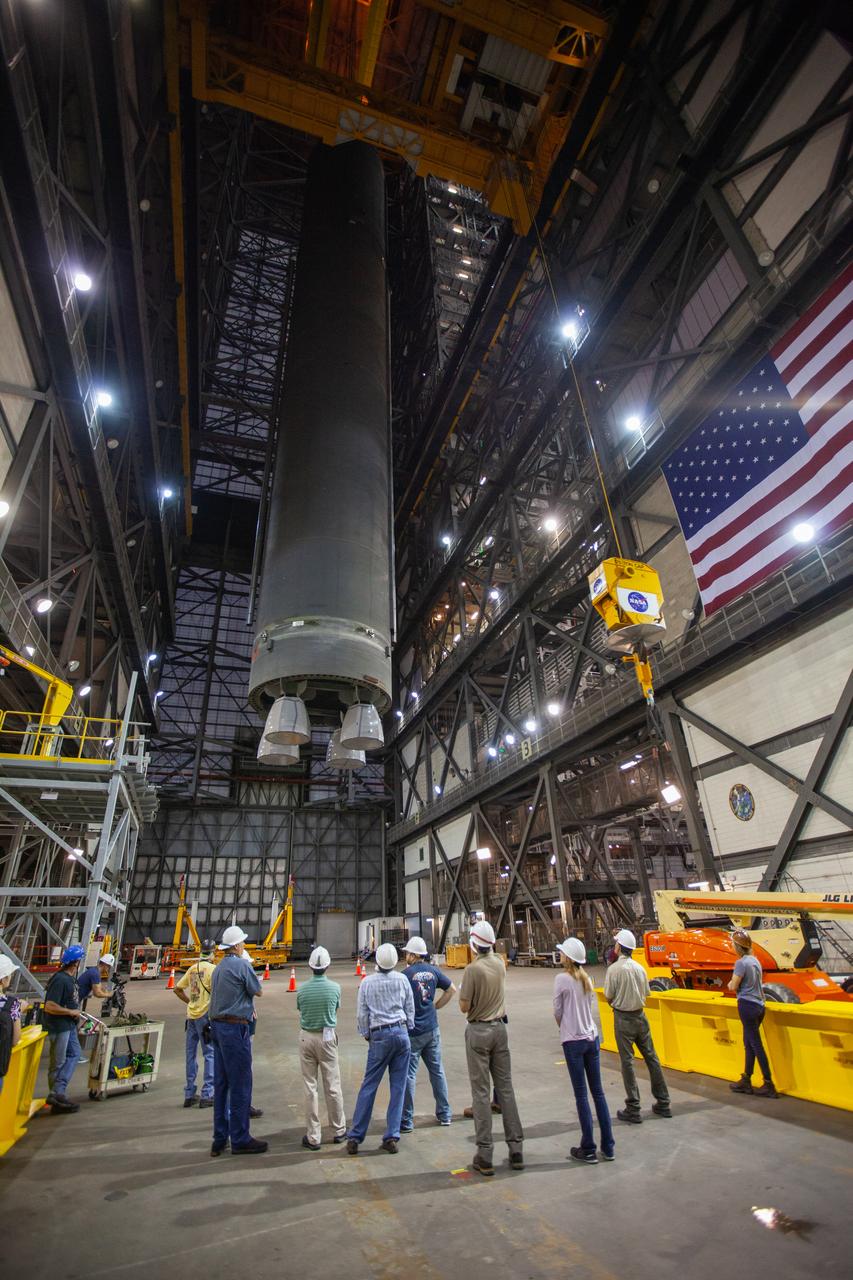 Inside the Vehicle Assembly Building at NASA’s Kennedy Space Center in Florida, workers watch as two cranes are used to lift the Space Launch System (SLS) Core Stage pathfinder high up in the transfer aisle on Oct. 16, 2019. The pathfinder will be lifted up to the 16th level and lowered into High Bay 3. The 212-foot-long core stage pathfinder arrived on NASA's Pegasus Barge at Kennedy’s Launch Complex 39 turn basin wharf on Sept. 27, 2019. The Pegasus Barge made its first delivery to Kennedy in support of the agency's Artemis missions. The pathfinder is being used by Exploration Ground Systems and its contractor, Jacobs, to practice offloading, moving and stacking maneuvers, using important ground support equipment to train employees and certify all the equipment works properly. The pathfinder will stay at Kennedy through at least the month of October before trekking back to NASA's Michoud Assembly Facility in Louisiana.