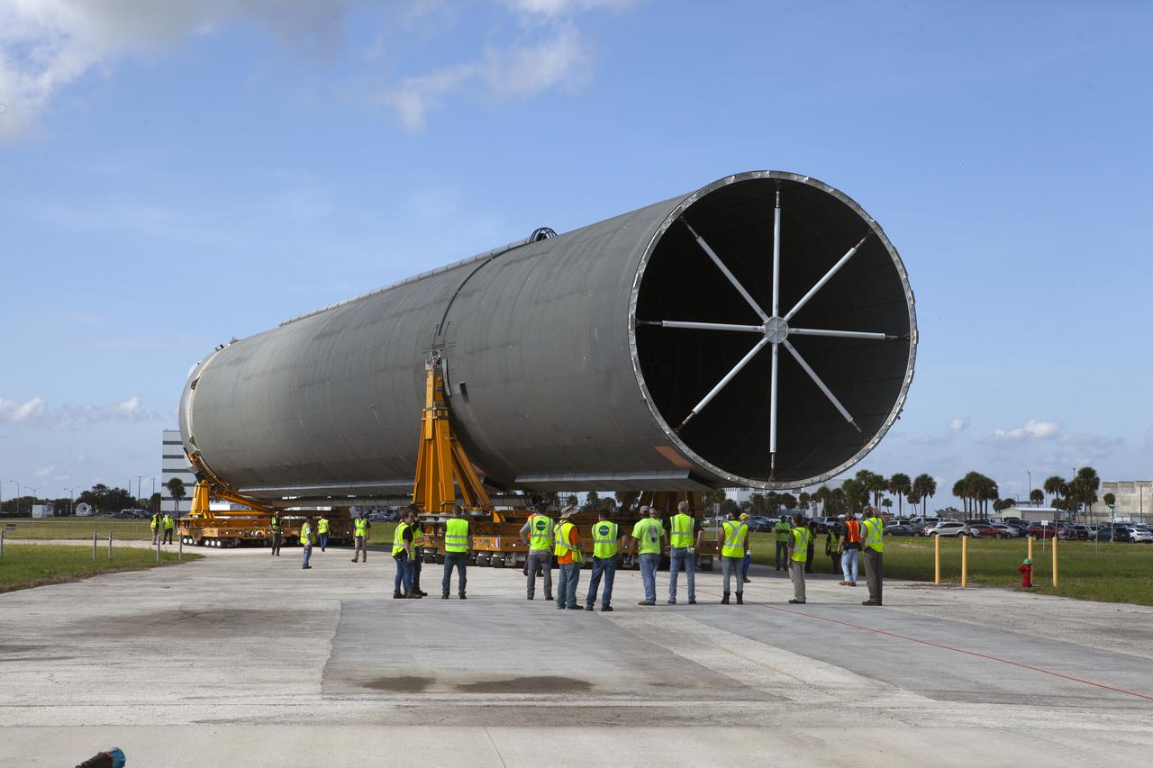 The top portion of the 212-foot-long Space Launch System (SLS) rocket core stage pathfinder is in view as the transporter it is secured on moves in reverse to position the pathfinder for the move to the Pegasus barge at the Launch Complex 39 turn basin wharf at NASA’s Kennedy Space Center in Florida on Oct. 28, 2019. The core stage pathfinder is a full-scale mock-up of the rocket's core stage. It was used by the Exploration Ground Systems Program and their contractor, Jacobs, to practice offloading, moving and stacking maneuvers inside the Vehicle Assembly Building, using important ground support equipment to train employees and certify all the equipment works properly. The pathfinder was at Kennedy for about a month. It will make the trek back to NASA's Michoud Assembly Facility in Louisiana.