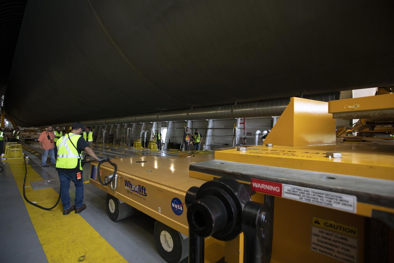 Inside the Pegasus barge at the Launch Complex 39 turn basin wharf, NASA and Jacobs workers assist as the 212-foot-long Space Launch System (SLS) rocket core stage pathfinder is moved inside the barge on Oct. 28, 2019 at NASA’s Kennedy Space Center in Florida. The core stage pathfinder is a full-scale mock-up of the rocket's core stage. It was used by the Exploration Ground Systems Program and their contractor, Jacobs, to practice offloading, moving and stacking maneuvers inside the Vehicle Assembly Building, using important ground support equipment to train employees and certify all the equipment works properly. The pathfinder was at Kennedy for about a month. It will make the trek back to NASA's Michoud Assembly Facility in Louisiana.