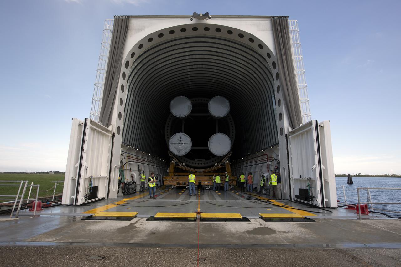NASA and Jacobs workers assist as the 212-foot-long Space Launch System (SLS) rocket core stage pathfinder is moved inside the Pegasus barge at the Launch Complex 39 turn basin wharf at NASA’s Kennedy Space Center in Florida on Oct. 28, 2019. The core stage pathfinder is a full-scale mock-up of the rocket's core stage. It was used by the Exploration Ground Systems Program and their contractor, Jacobs, to practice offloading, moving and stacking maneuvers inside the Vehicle Assembly Building, using important ground support equipment to train employees and certify all the equipment works properly. The pathfinder was at Kennedy for about a month. It will make the trek back to NASA's Michoud Assembly Facility in Louisiana.