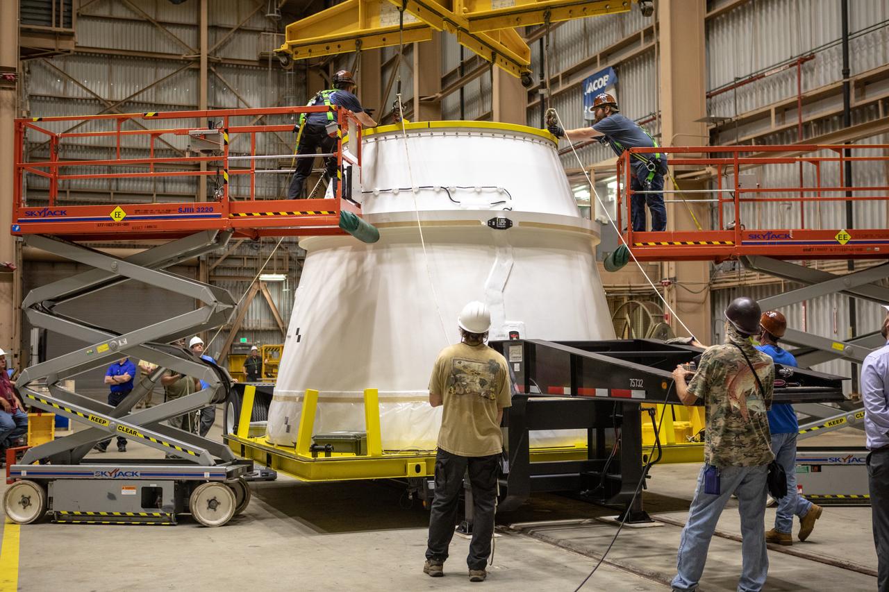 Workers attach a crane to the first Northrop Grumman aft exit cone to arrive for the Space Launch System’s solid rocket boosters inside the Rotation, Processing and Surge Facility at NASA’s Kennedy Space Center in Florida on Nov. 4, 2019. The aft exit cone was shipped from Promontory, Utah. It will be checked out and prepared for the Artemis I uncrewed test flight. The aft exit cones sit at the bottommost part of the twin boosters. They are attached to the aft skirts, which contain the booster separation motors. The exit cones help to protect the aft skirts during launch.