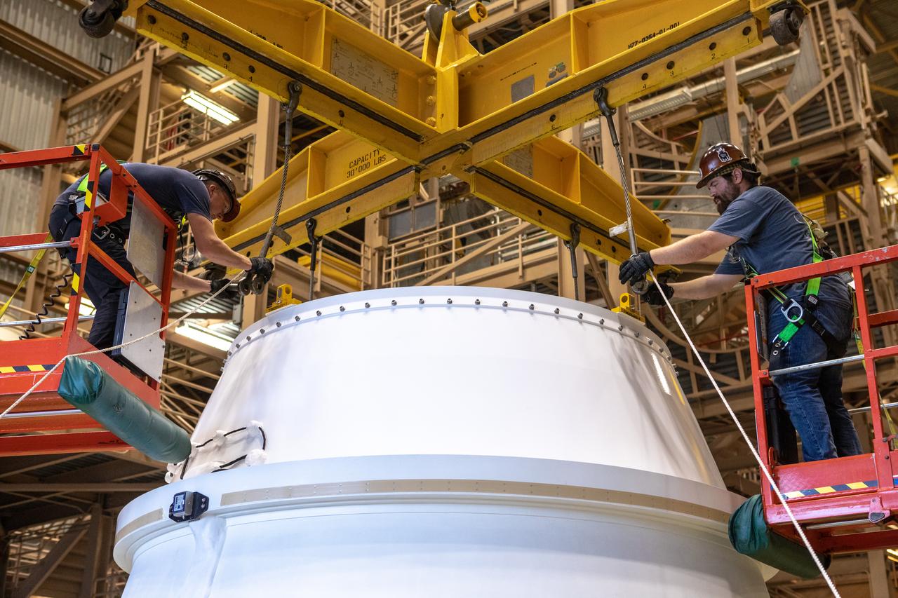 Workers attach a crane to the first Northrop Grumman aft exit cone to arrive for the Space Launch System’s solid rocket boosters inside the Rotation, Processing and Surge Facility at NASA’s Kennedy Space Center in Florida on Nov. 4, 2019. The aft exit cone was shipped from Promontory, Utah. It will be checked out and prepared for the Artemis I uncrewed test flight. The aft exit cones sit at the bottommost part of the twin boosters. They are attached to the aft skirts, which contain the booster separation motors. The exit cones help to protect the aft skirts during launch.