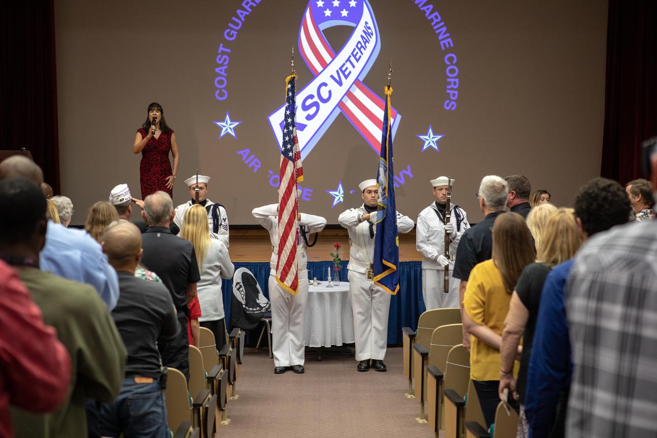 The National Anthem is sung by Suzy Cunningham, NASA Strategy and Integration manager, during a Veterans Day observance ceremony held in the Kennedy Space Center’s Training Auditorium in Florida on Nov. 7, 2019. During the event, Kennedy was named a Purple Heart Entity by the Military Order of the Purple Heart, becoming the first NASA center to receive this designation for support and services provided to veterans through the spaceport’s Veterans employee resource group. Attendees included Kennedy employees and more than 20 Purple Heart recipients. Following the award presentation, Christopher Vedvick, a combat wounded veteran and Military Order of the Purple Heart department of Florida commander, spoke about his experience serving in the United States Army before retiring, his involvement in the Military Order of the Purple Heart and the purpose of the organization. 