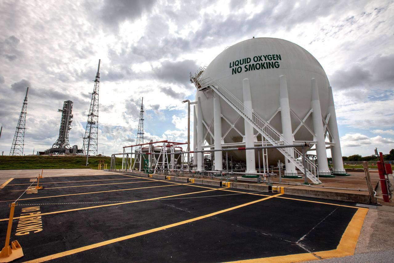 A liquid oxygen storage tank, with a view of the mobile launcher on the pad surface in the background, is photographed at Launch Pad 39B on Nov. 8, 2019, at NASA’s Kennedy Space Center in Florida. The agency’s Exploration Ground Systems oversaw testing of the pad’s cryogenic systems – the infrastructure that will support the flow of liquid hydrogen and liquid oxygen from the storage tanks to the Space Launch System (SLS) rocket – in preparation for the launch of SLS with the Orion spacecraft atop for the uncrewed Artemis I mission. Each of the liquid oxygen and liquid hydrogen tanks can hold more than 800,000 gallons of propellant. The liquid oxygen will require the use of pumps to push it from the tank to the rocket, while the lighter liquid hydrogen will make its way up to the pad using gaseous hydrogen to pressurize the sphere. 