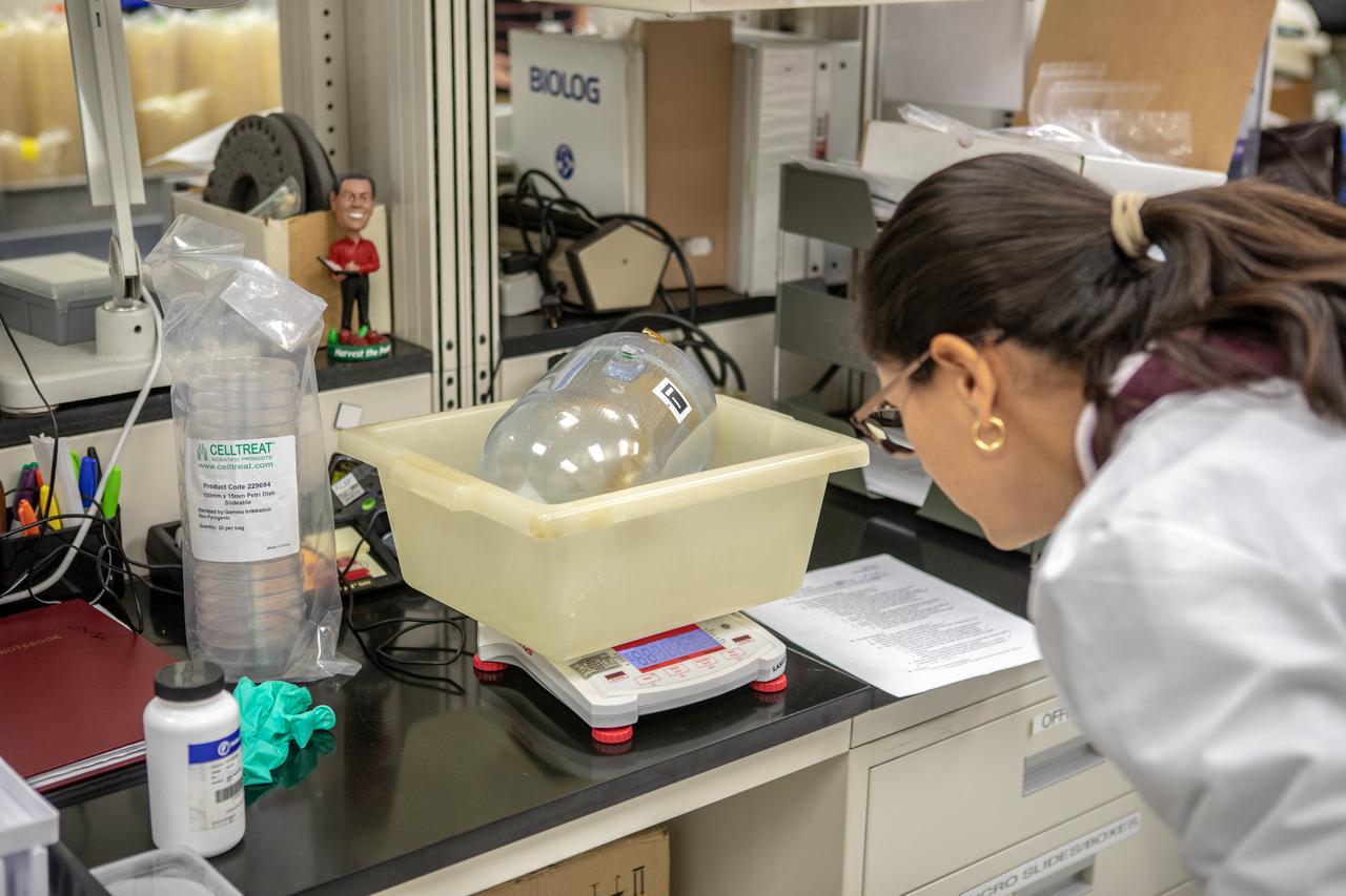 Kennedy Space Center’s Carolina Franco, Ph.D., weighs one of the water tanks, recently returned to the center after remaining on the International Space Station for the past five years, in the Florida spaceport’s Neil Armstrong Operations and Checkout Building on Nov. 13, 2019. Two tanks containing water were first sent to the orbiting laboratory in 2014 to study slosh, or the movement of water, in a zero-gravity environment to help engineers predict the movement of propellant in rocket tanks. Kennedy’s Air and Water Revitalization lab is studying the water tanks to determine if there is, or was, any microbial growth within them. The results will help NASA determine whether clean water can be stored in space for long-duration missions, an essential component to keeping astronauts safe and healthy as the agency prepares for missions to the Moon and beyond to Mars. 