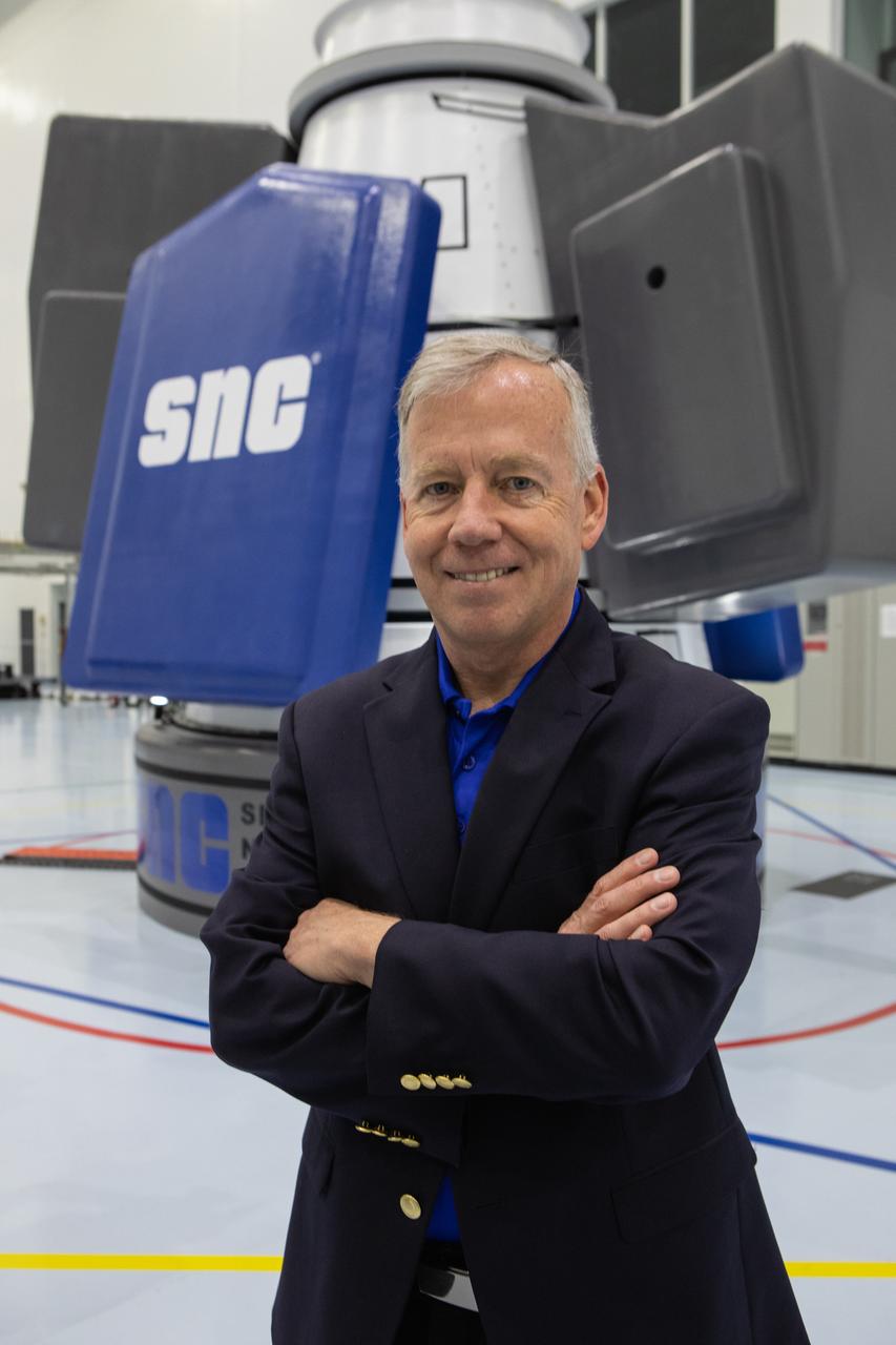 Steve Lindsey, senior vice president of strategy for Sierra Nevada Corporation Space Systems and a former NASA astronaut, poses in front of the company’s Shooting Star cargo module in the Space Station Processing Facility high bay at Kennedy Space Center on Nov. 19, 2019. Shooting Star will attach to the back of the company’s Dream Chaser spacecraft. The cargo module will deliver more than 12,000 pounds of supplies and other cargo to the International Space Station for NASA as part of the Commercial Resupply Services-2 contract.