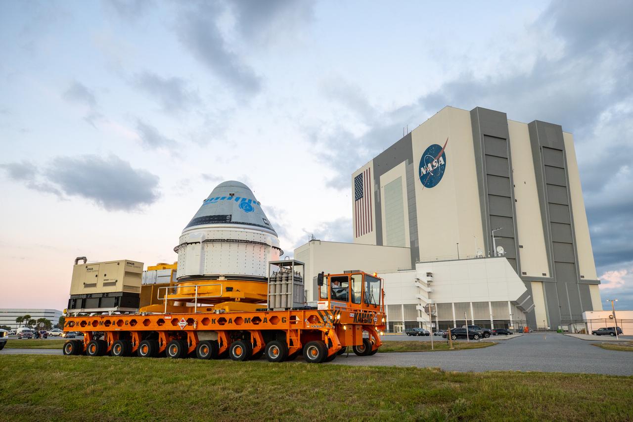 Boeing’s CST-100 Starliner spacecraft passes by the Vehicle Assembly Building at NASA’s Kennedy Space Center in Florida on Nov. 21, 2019, making its way to the Space Launch Complex 41 Vertical Integration Facility at Cape Canaveral Air Force Station. At the pad, Starliner will be secured atop a United Launch Alliance Atlas V rocket in preparation for Boeing’s uncrewed Orbital Flight Test to the International Space Station for NASA’s Commercial Crew Program.
