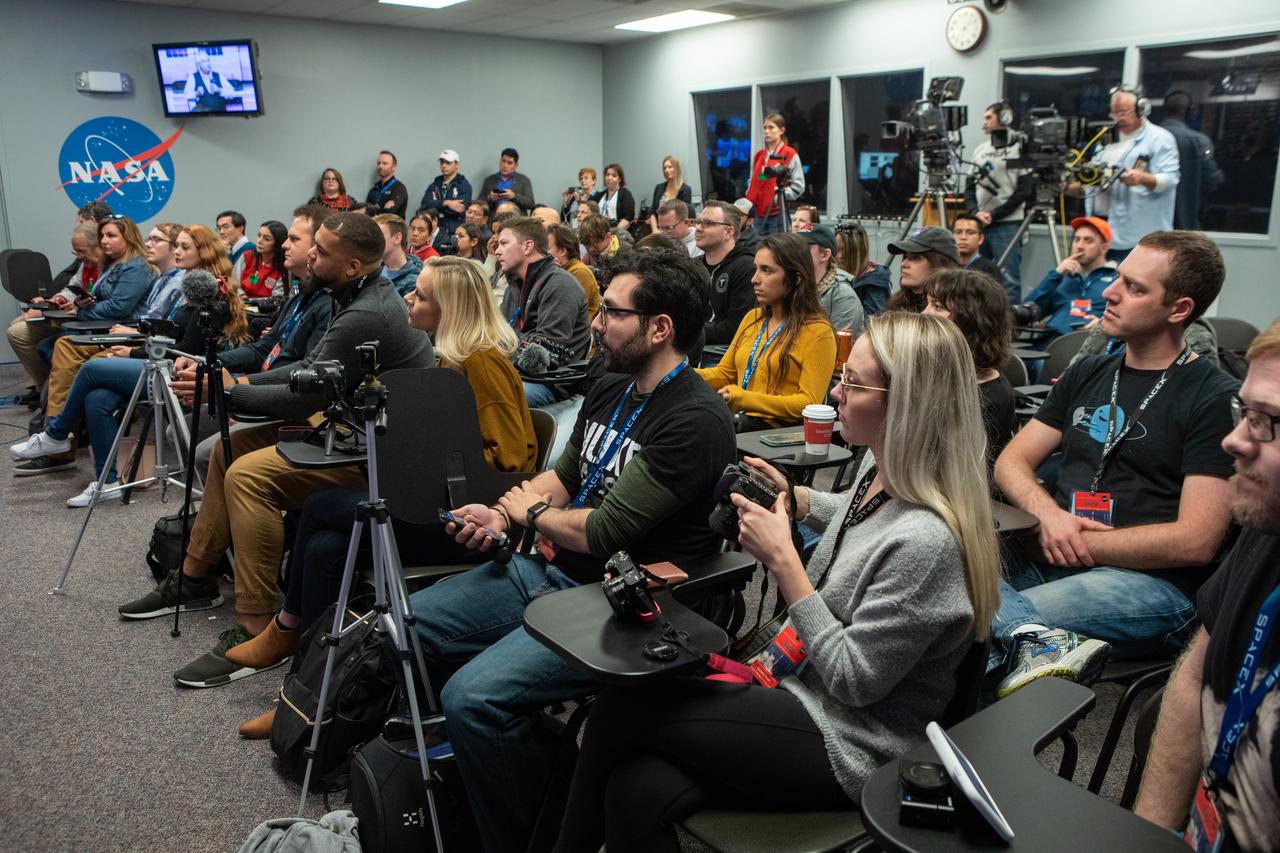 Members of the news and social media listen to a What's On Board Briefing on Dec. 3, 2019, for SpaceX's 19th Commercial Resupply Services (CRS-19) mission for NASA to the International Space Station at the agency's Kennedy Space Center in Florida. The SpaceX Falcon 9 rocket and Dragon cargo module are scheduled to launch on Dec. 4, 2019, from Space Launch Complex 40 on Cape Canaveral Air Force Station in Florida.