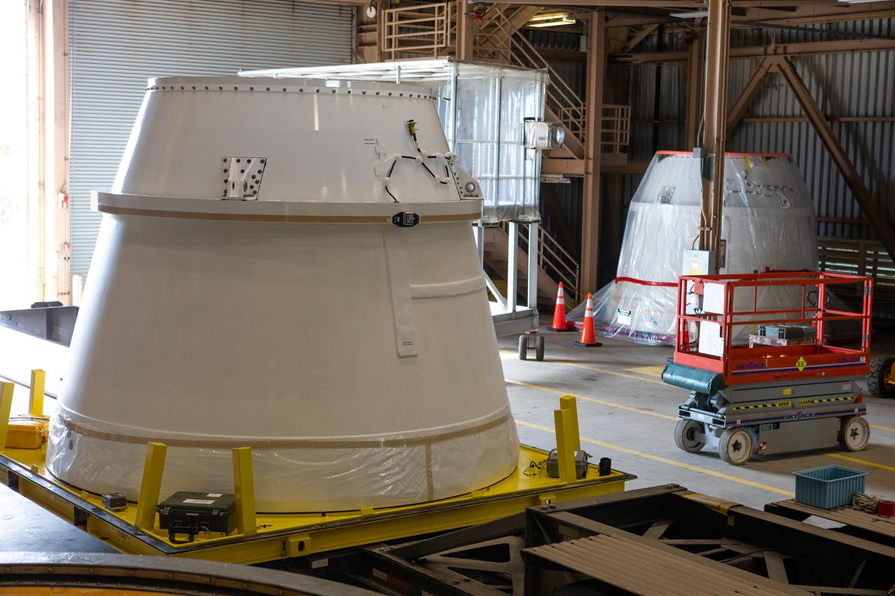 Both of the Northrop Grumman-manufactured aft exit cones for the Space Launch System’s solid rocket boosters are in view inside the Rotation, Processing and Surge Facility at NASA’s Kennedy Space Center in Florida on Dec. 9, 2019. Both arrived from Promontory, Utah. The right aft exit cone is in the foreground, and the left aft exit cone is in the background. They will be checked out and prepared for the Artemis I uncrewed test flight. The aft exit cones sit at the bottommost part of the twin boosters. The cones help provide added thrust for the boosters, while protecting the aft skirts from the thermal environment during launch.