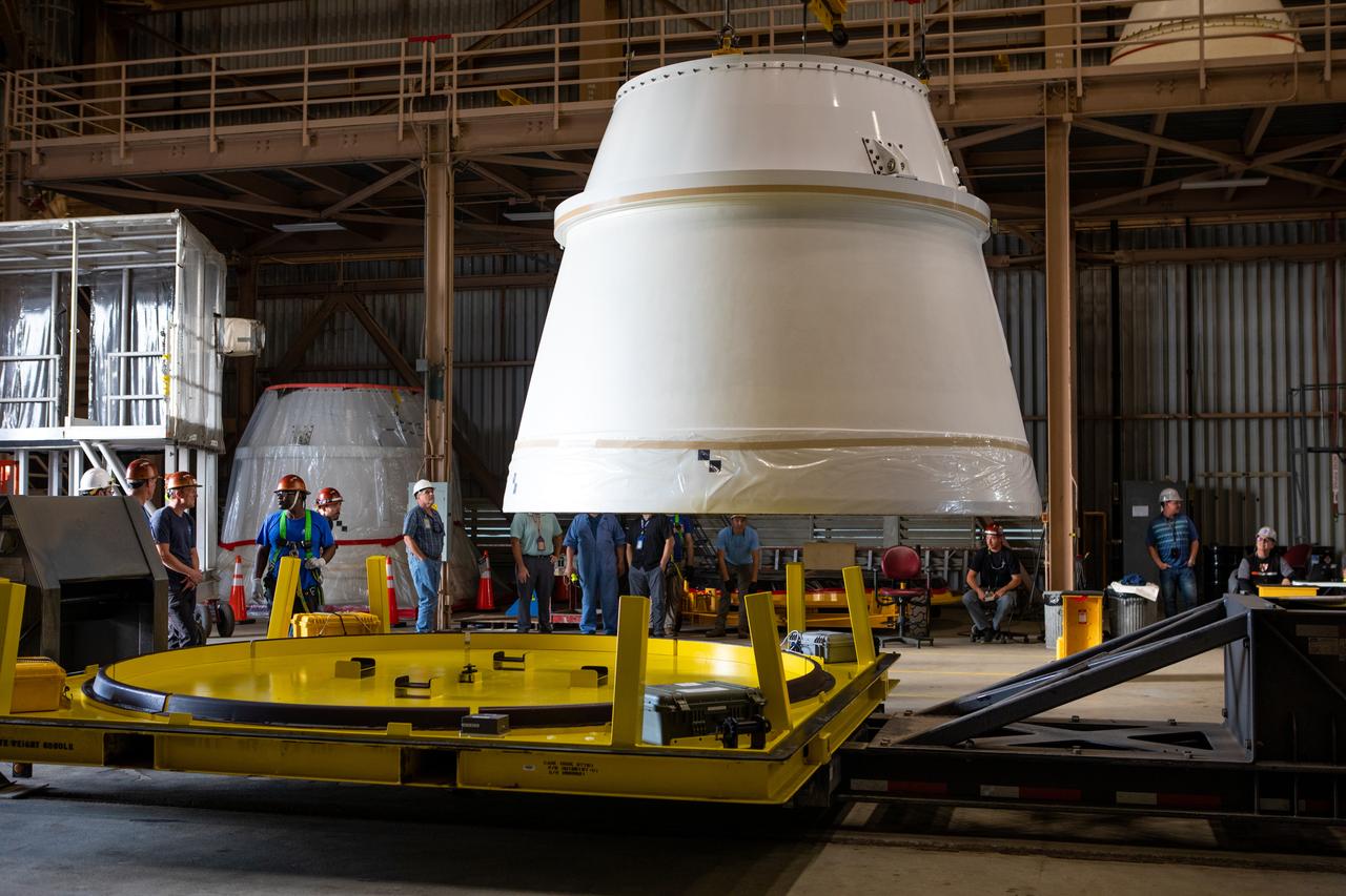 A crane is used to lift the Northrop Grumman right-manufactured aft exit cone for the Space Launch System’s solid rocket boosters away from its shipping base for securing on a processing stand inside the Rotation, Processing and Surge Facility at NASA’s Kennedy Space Center in Florida on Dec. 9, 2019. The right and left aft exit cones were shipped from Promontory, Utah. They will be checked out and prepared for the Artemis I uncrewed test flight. The aft exit cones sit at the bottommost part of the twin boosters. The cones help provide added thrust for the boosters, while protecting the aft skirts from the thermal environment during launch.