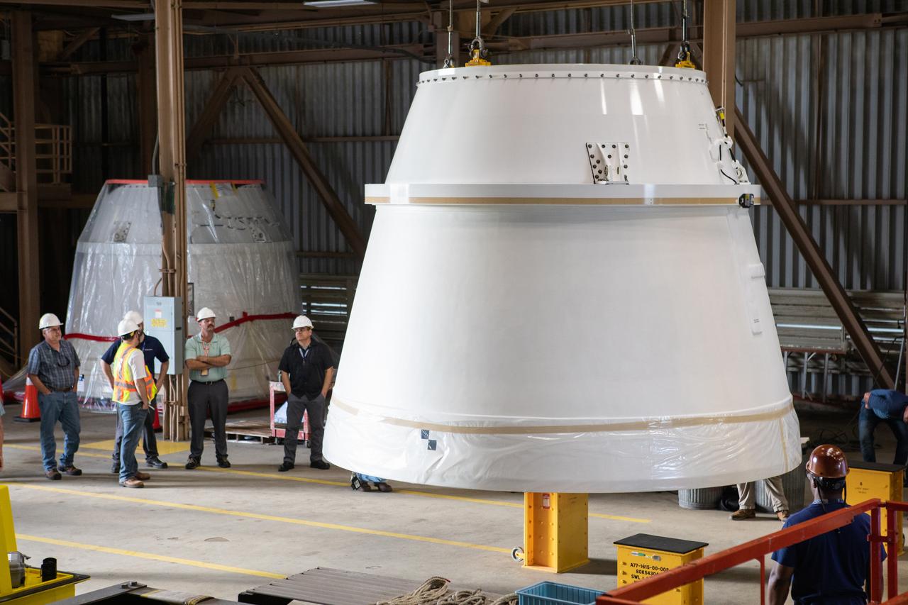 The second of two Northrop Grumman-manufactured aft exit cones to arrive for the Space Launch System’s solid rocket boosters is moved by crane inside the Rotation, Processing and Surge Facility at NASA’s Kennedy Space Center in Florida on Dec. 9, 2019. Both aft exit cone were shipped from Promontory, Utah. The left aft exit cone is in view in the background. They will be checked out and prepared for the Artemis I uncrewed test flight. The aft exit cones sit at the bottommost part of the twin boosters. The cones help provide added thrust for the boosters, while protecting the aft skirts from the thermal environment during launch.