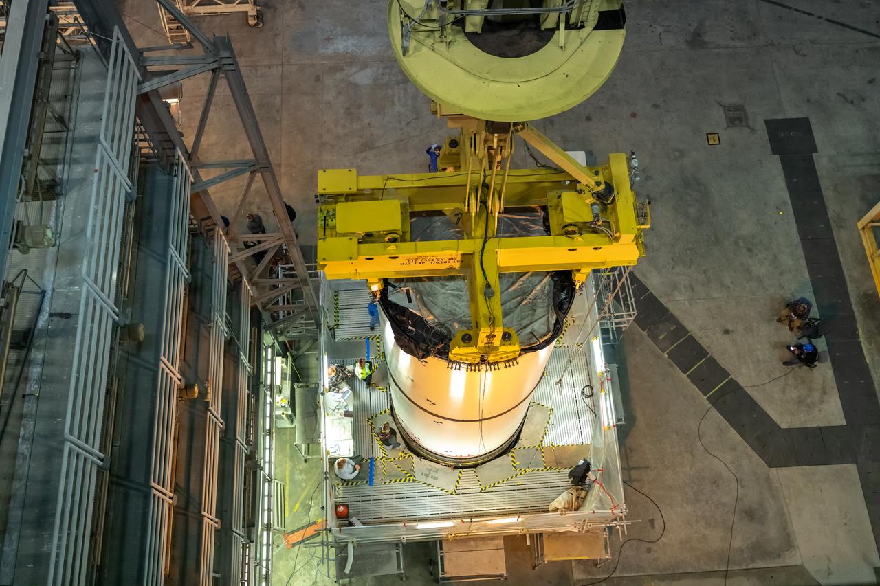 In High Bay 4 of the Vehicle Assembly Building at NASA’s Kennedy Space Center in Florida, a crane lowers one Space Launch System (SLS) solid rocket booster pathfinder segment onto another segment during a training exercise on Jan. 8, 2020. A team of engineers with Exploration Ground Systems and crane operators and technicians with contractor Jacobs are practicing lifting, moving and stacking maneuvers, using important ground support equipment to train employees and certify all the equipment works properly. The booster pathfinders are inert, full-scale replicas of the actual booster hardware that will be attached to the SLS rocket for Artemis missions. The five-segment, 17-story-tall twin boosters will provide 3.6 million pounds of thrust each at liftoff to help launch Orion on Artemis I, its first uncrewed mission beyond the Moon.