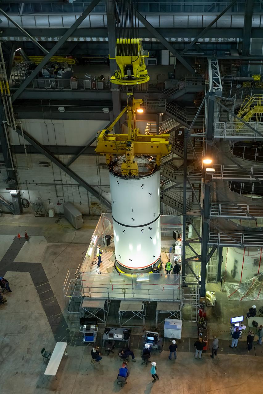In High Bay 4 of the Vehicle Assembly Building at NASA’s Kennedy Space Center in Florida, a crane lowers one Space Launch System (SLS) solid rocket booster pathfinder segment onto another segment during a training exercise on Jan. 8, 2020. A team of engineers with Exploration Ground Systems and crane operators and technicians with contractor Jacobs are practicing lifting, moving and stacking maneuvers, using important ground support equipment to train employees and certify all the equipment works properly. The booster pathfinders are inert, full-scale replicas of the actual booster hardware that will be attached to the SLS rocket for Artemis missions. The five-segment, 17-story-tall twin boosters will provide 3.6 million pounds of thrust each at liftoff to help launch Orion on Artemis I, its first uncrewed mission beyond the Moon.