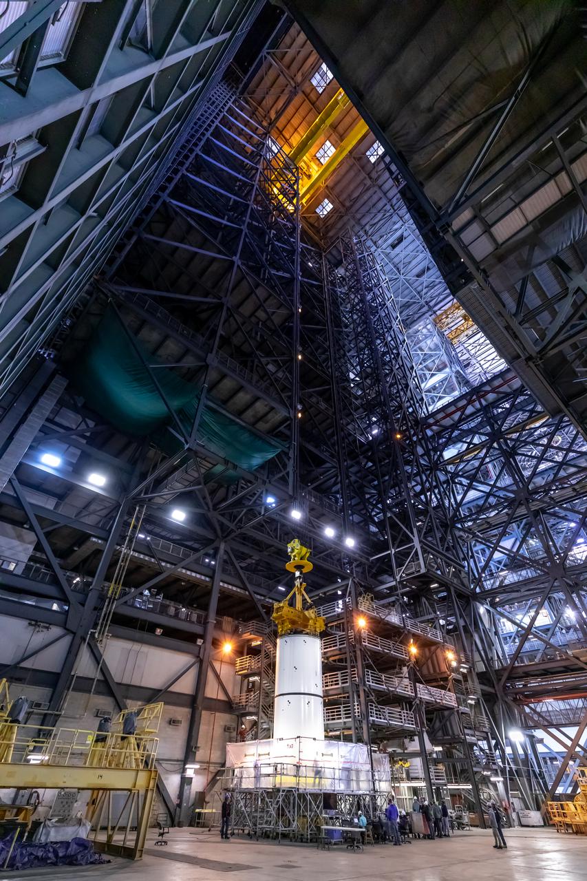 In High Bay 4 of the Vehicle Assembly Building at NASA’s Kennedy Space Center in Florida, a crane lowers Space Launch System (SLS) solid rocket booster pathfinder segments onto a platform during a training exercise on Jan. 8, 2020. A team of engineers with Exploration Ground Systems and crane operators and technicians with contractor Jacobs are practicing lifting, moving and stacking maneuvers, using important ground support equipment to train employees and certify all the equipment works properly. The booster pathfinders are inert, full-scale replicas of the actual booster hardware that will be attached to the SLS rocket for Artemis missions. The five-segment, 17-story-tall twin boosters will provide 3.6 million pounds of thrust each at liftoff to help launch Orion on Artemis I, its first uncrewed mission beyond the Moon.