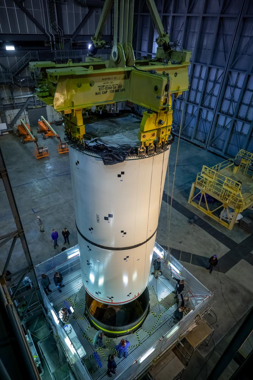 In High Bay 4 of the Vehicle Assembly Building at NASA’s Kennedy Space Center in Florida, pathfinders, or full-scale replicas of Space Launch System (SLS) solid rocket booster segments, are being stacked during a training exercise on Jan. 8, 2020. A team of engineers with Exploration Ground Systems and crane operators and technicians with contractor Jacobs are practicing lifting, moving and stacking maneuvers, using important ground support equipment to train employees and certify all the equipment works properly. The booster pathfinders are inert, full-scale replicas of the actual booster hardware that will be attached to the SLS rocket for Artemis missions. The five-segment, 17-story-tall twin boosters will provide 3.6 million pounds of thrust each at liftoff to help launch Orion on Artemis I, its first uncrewed mission beyond the Moon.