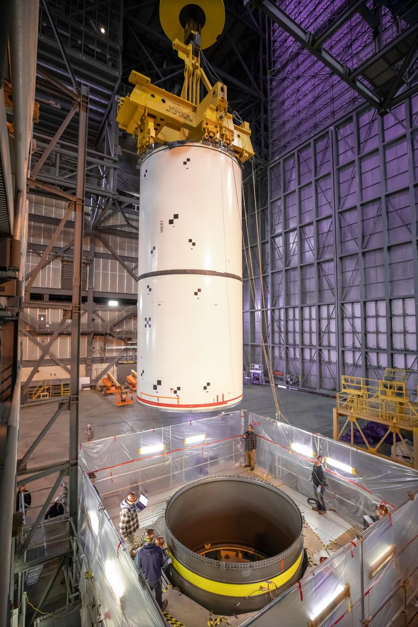 In High Bay 4 of the Vehicle Assembly Building at NASA’s Kennedy Space Center in Florida, pathfinders, or full-scale replicas of Space Launch System (SLS) solid rocket booster segments, are being stacked during a training exercise on Jan. 8, 2020. A team of engineers with Exploration Ground Systems and crane operators and technicians with contractor Jacobs are practicing lifting, moving and stacking maneuvers, using important ground support equipment to train employees and certify all the equipment works properly. The booster pathfinders are inert, full-scale replicas of the actual booster hardware that will be attached to the SLS rocket for Artemis missions. The five-segment, 17-story-tall twin boosters will provide 3.6 million pounds of thrust each at liftoff to help launch Orion on Artemis I, its first uncrewed mission beyond the Moon.