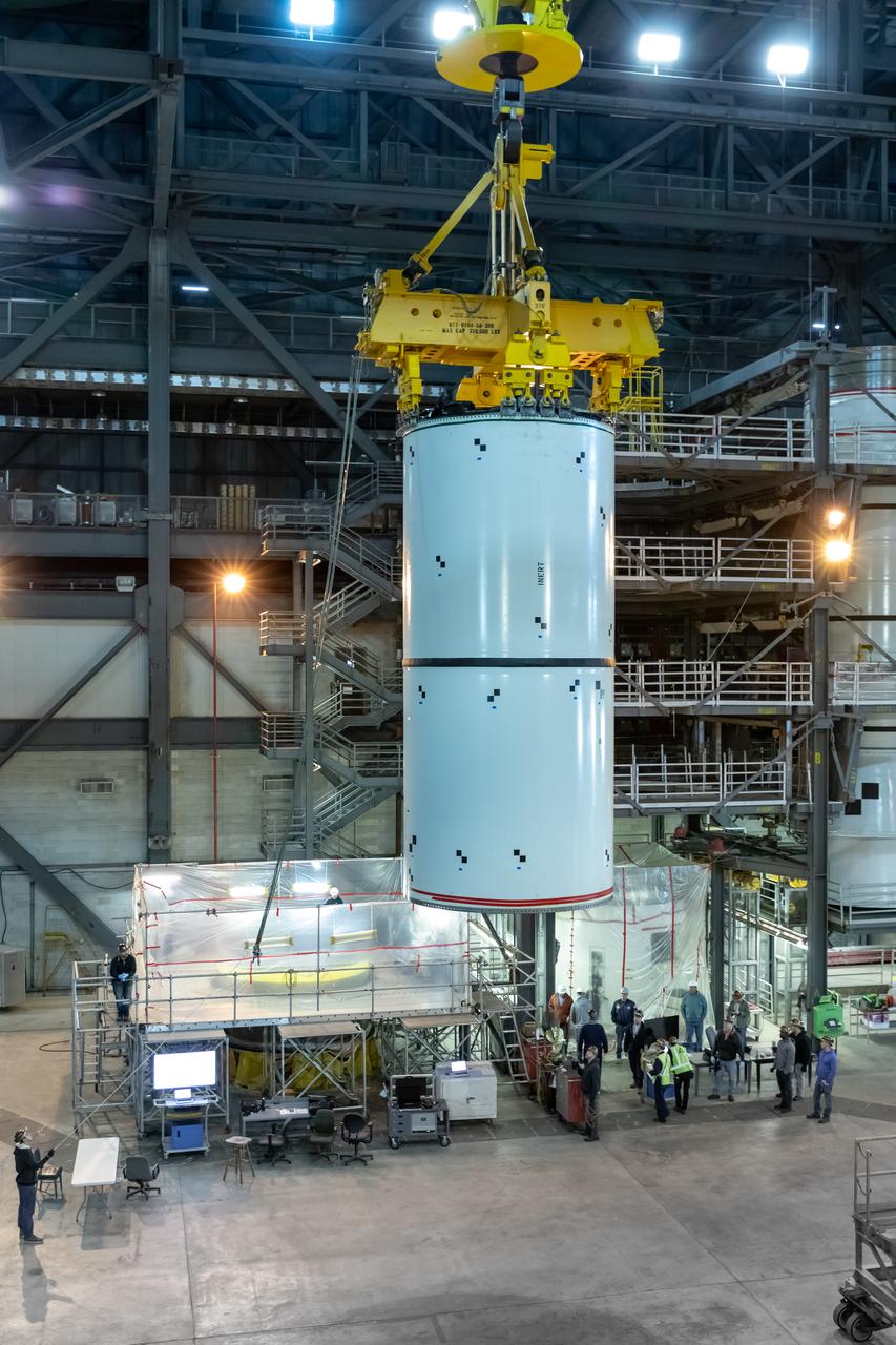 In High Bay 4 of the Vehicle Assembly Building at NASA’s Kennedy Space Center in Florida, a crane moves Space Launch System (SLS) solid rocket booster pathfinder segments toward a platform during a training exercise on Jan. 8, 2020. A team of engineers with Exploration Ground Systems and crane operators and technicians with contractor Jacobs are practicing lifting, moving and stacking maneuvers, using important ground support equipment to train employees and certify all the equipment works properly. The booster pathfinders are inert, full-scale replicas of the actual booster hardware that will be attached to the SLS rocket for Artemis missions. The five-segment, 17-story-tall twin boosters will provide 3.6 million pounds of thrust each at liftoff to help launch Orion on Artemis I, its first uncrewed mission beyond the Moon.