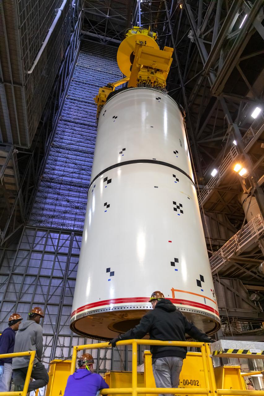 In High Bay 4 of the Vehicle Assembly Building at NASA’s Kennedy Space Center in Florida, a crane lowers Space Launch System (SLS) solid rocket booster pathfinder segments onto a platform during a training exercise on Jan. 8, 2020. A team of engineers with Exploration Ground Systems and crane operators and technicians with contractor Jacobs are practicing lifting, moving and stacking maneuvers, using important ground support equipment to train employees and certify all the equipment works properly. The booster pathfinders are inert, full-scale replicas of the actual booster hardware that will be attached to the SLS rocket for Artemis missions. The five-segment, 17-story-tall twin boosters will provide 3.6 million pounds of thrust each at liftoff to help launch Orion on Artemis I, its first uncrewed mission beyond the Moon.