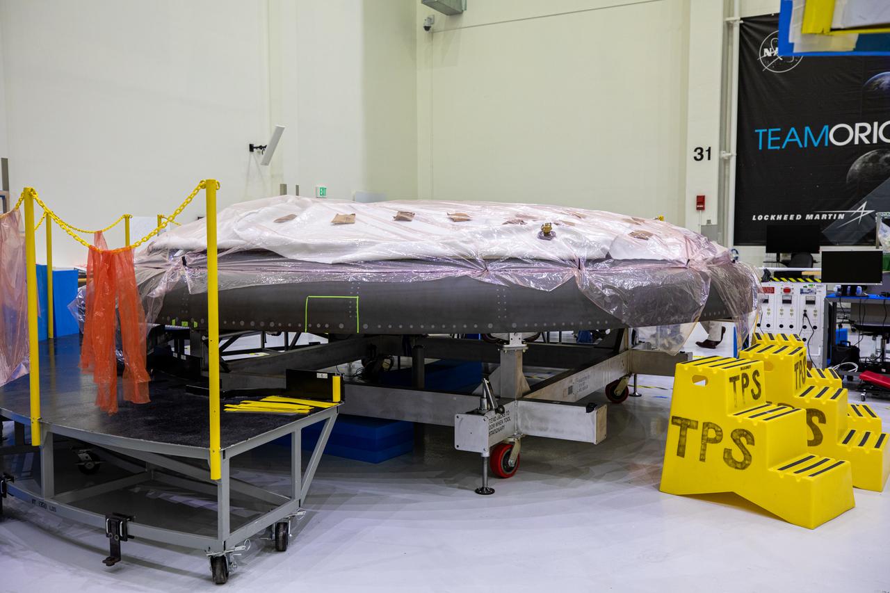 The heat shield for Orion’s Artemis II mission is in view secured on a work stand in the Neil Armstrong Operations and Checkout Building high bay at NASA’s Kennedy Space Center in Florida on Jan. 9, 2020. Work continues to prepare the heat shield for flight, including applying Avcoat, an ablative material that will provide thermal protection. The heat shield, measuring roughly 16 feet in diameter, will protect astronauts upon re-entry on the second mission of Artemis. Artemis II, the first crewed mission in the series of missions to the Moon and on to Mars, will confirm all of the Orion spacecraft’s systems operate as designed in the actual environment of deep space with astronauts aboard.