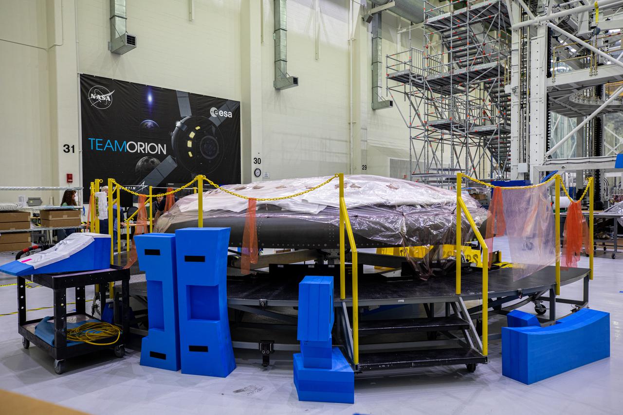 The heat shield for Orion’s Artemis II mission is in view secured on a work stand in the Neil Armstrong Operations and Checkout Building high bay at NASA’s Kennedy Space Center in Florida on Jan. 9, 2020. Work continues to prepare the heat shield for flight, including applying Avcoat, an ablative material that will provide thermal protection. The heat shield, measuring roughly 16 feet in diameter, will protect astronauts upon re-entry on the second mission of Artemis. Artemis II, the first crewed mission in the series of missions to the Moon and on to Mars, will confirm all of the Orion spacecraft’s systems operate as designed in the actual environment of deep space with astronauts aboard.