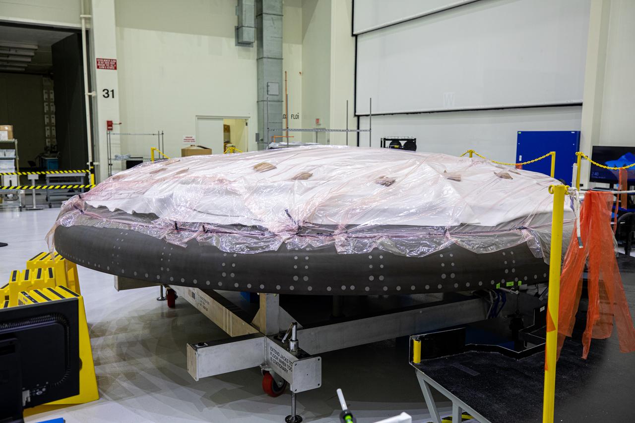 The heat shield for Orion’s Artemis II mission is in view secured on a work stand in the Neil Armstrong Operations and Checkout Building high bay at NASA’s Kennedy Space Center in Florida on Jan. 9, 2020. Work continues to prepare the heat shield for flight, including applying Avcoat, an ablative material that will provide thermal protection. The heat shield, measuring roughly 16 feet in diameter, will protect astronauts upon re-entry on the second mission of Artemis. Artemis II, the first crewed mission in the series of missions to the Moon and on to Mars, will confirm all of the Orion spacecraft’s systems operate as designed in the actual environment of deep space with astronauts aboard.