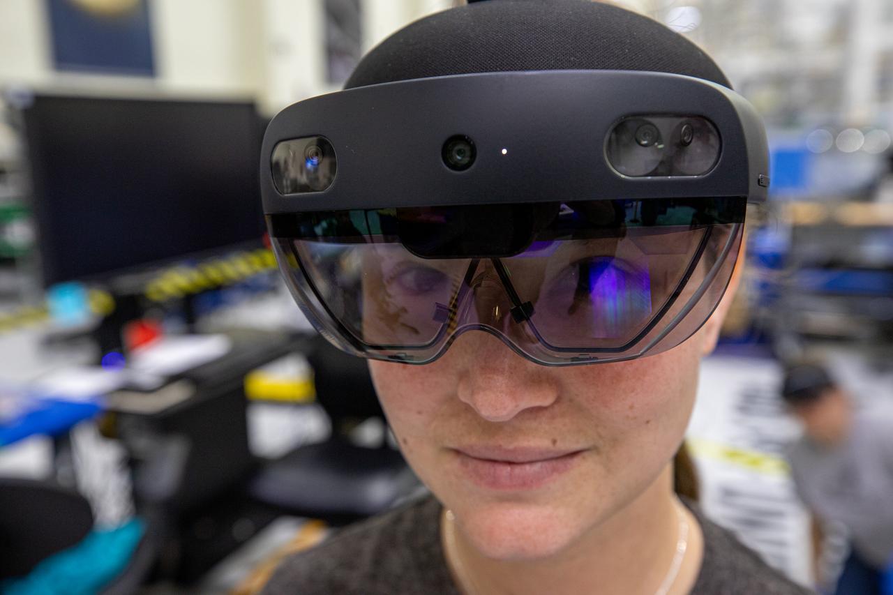 Mary Lakaszcyck, a technician with ASRC Federal Data Solutions, wears a pair of augmented reality (AR) goggles inside the high bay of the Neil Armstrong Operations and Checkout Building at NASA’s Kennedy Space Center in Florida on Jan. 16, 2020. Orion manufacturer Lockheed Martin provided the goggles to technicians to help place tapes where components will be installed on the Orion crew module adapter for NASA’s Artemis II mission, the first crewed mission aboard the spacecraft. Using the AR goggles saves significant labor and time to complete tasks. Manufactured by Microsoft, the goggles, called HoloLens2, are the second version used by Lockheed.