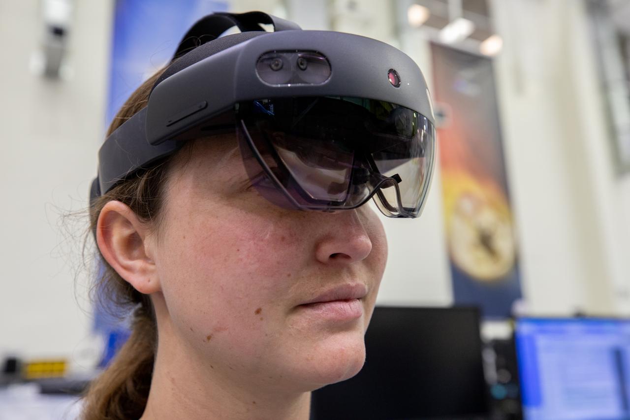 Mary Lakaszcyck, a technician with ASRC Federal Data Solutions, wears a pair of augmented reality (AR) goggles inside the high bay of the Neil Armstrong Operations and Checkout Building at NASA’s Kennedy Space Center in Florida on Jan. 16, 2020. Orion manufacturer Lockheed Martin provided the goggles to technicians to help place tapes where components will be installed on the Orion crew module adapter for NASA’s Artemis II mission, the first crewed mission aboard the spacecraft. Using the AR goggles saves significant labor and time to complete tasks. Manufactured by Microsoft, the goggles, called HoloLens2, are the second version used by Lockheed.
