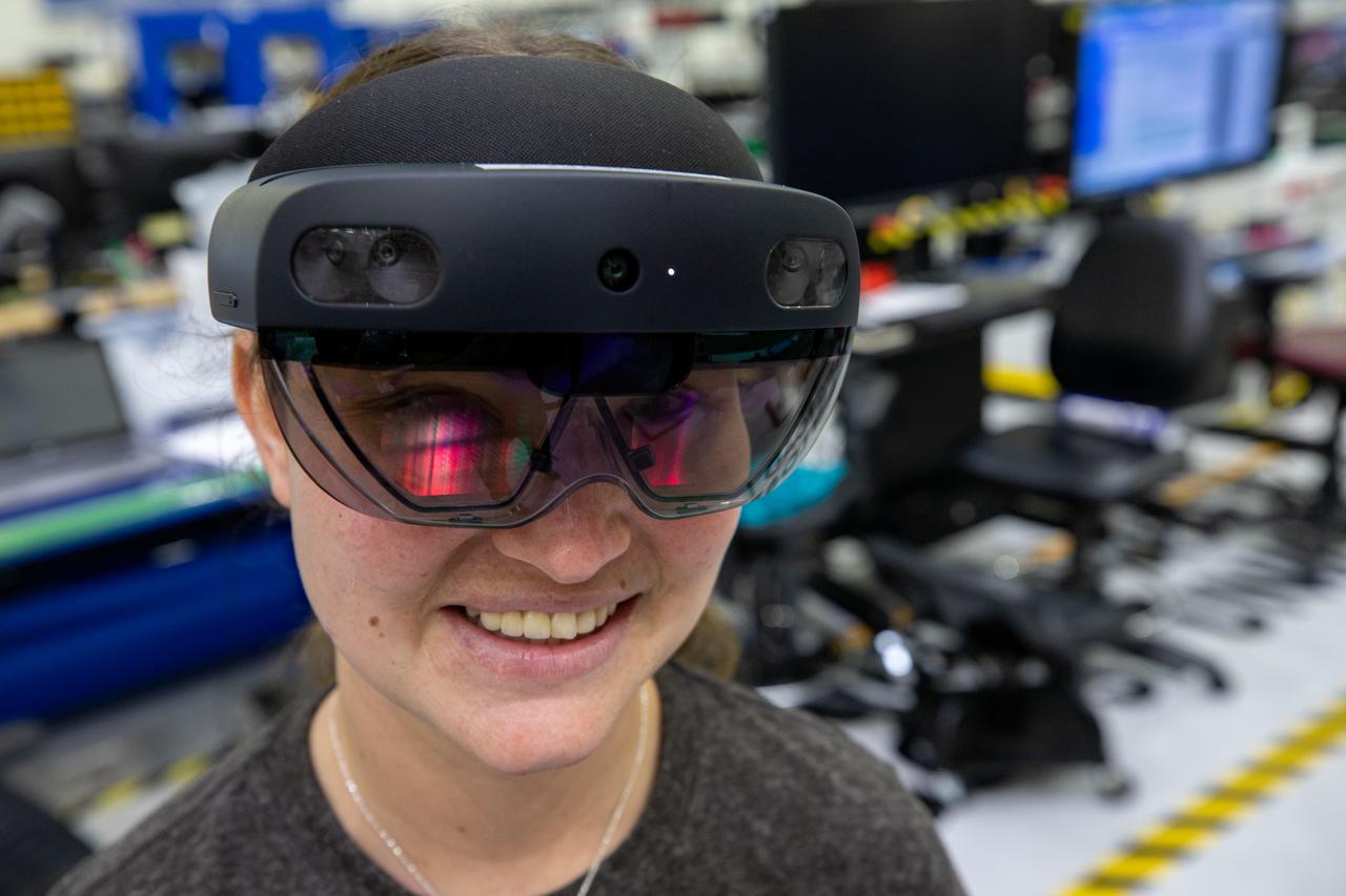 Mary Lakaszcyck, a technician with ASRC Federal Data Solutions, wears a pair of augmented reality (AR) goggles inside the high bay of the Neil Armstrong Operations and Checkout Building at NASA’s Kennedy Space Center in Florida on Jan. 16, 2020. Orion manufacturer Lockheed Martin provided the goggles to technicians to help place tapes where components will be installed on the Orion crew module adapter for NASA’s Artemis II mission, the first crewed mission aboard the spacecraft. Using the AR goggles saves significant labor and time to complete tasks. Manufactured by Microsoft, the goggles, called HoloLens2, are the second version used by Lockheed.