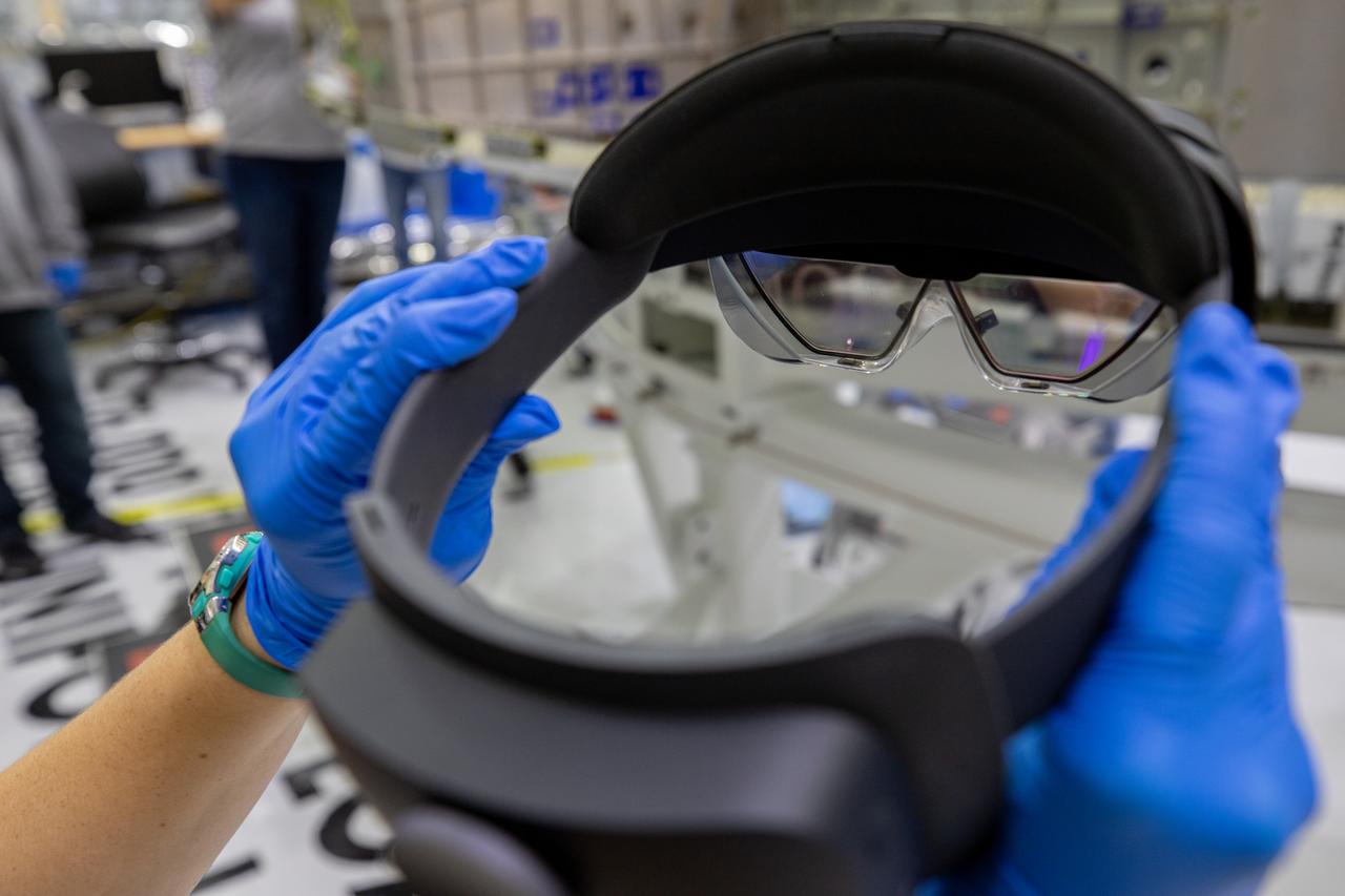 Mary Lakaszcyck, a technician with ASRC Federal Data Solutions, displays a pair of augmented reality (AR) goggles inside the high bay of the Neil Armstrong Operations and Checkout Building at NASA’s Kennedy Space Center in Florida on Jan. 16, 2020. Orion manufacturer Lockheed Martin provided the goggles to technicians to help place tapes where components will be installed on the Orion crew module adapter for NASA’s Artemis II mission, the first crewed mission aboard the spacecraft. Using the AR goggles saves significant labor and time to complete tasks. Manufactured by Microsoft, the goggles, called HoloLens2, are the second version used by Lockheed.
